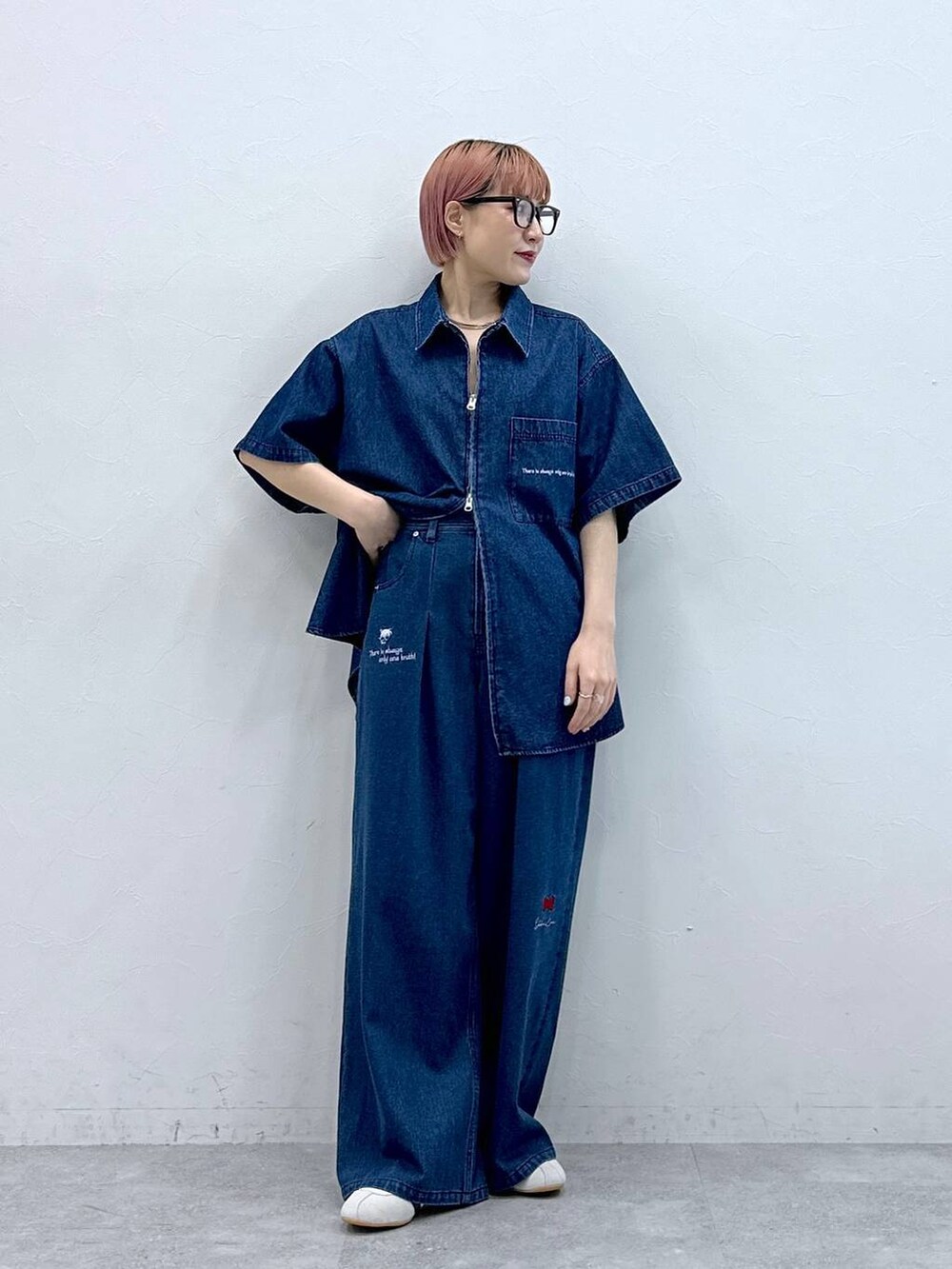 ホワイト系のスニーカー、グレー系のメガネを着用したレディースの春コーディネートの2枚目の写真