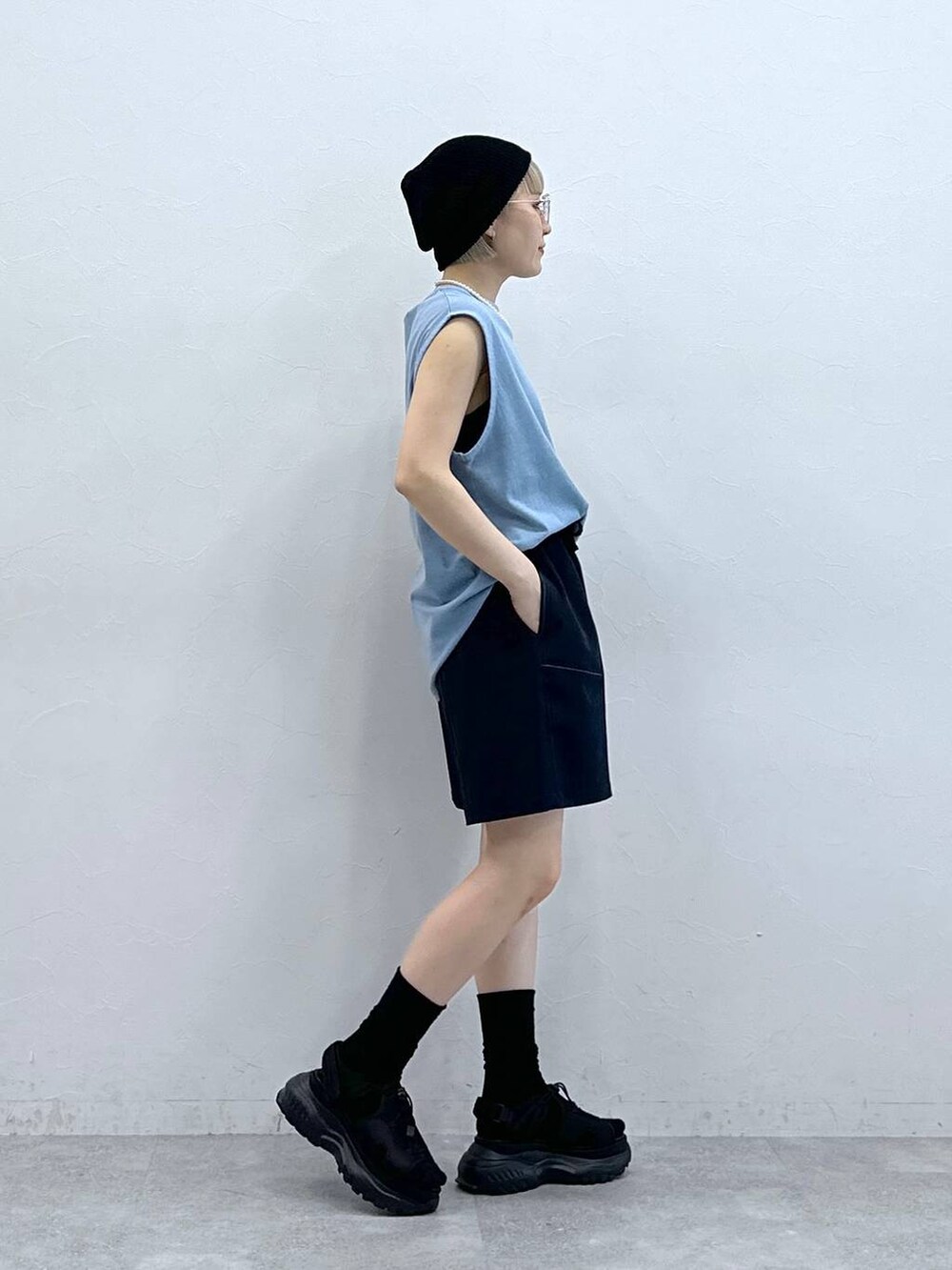 ブルー系のスラックス、ブラック系のサンダル、ブルー系のTシャツ/カットソーを着用したレディースの夏コーディネートの5枚目の写真