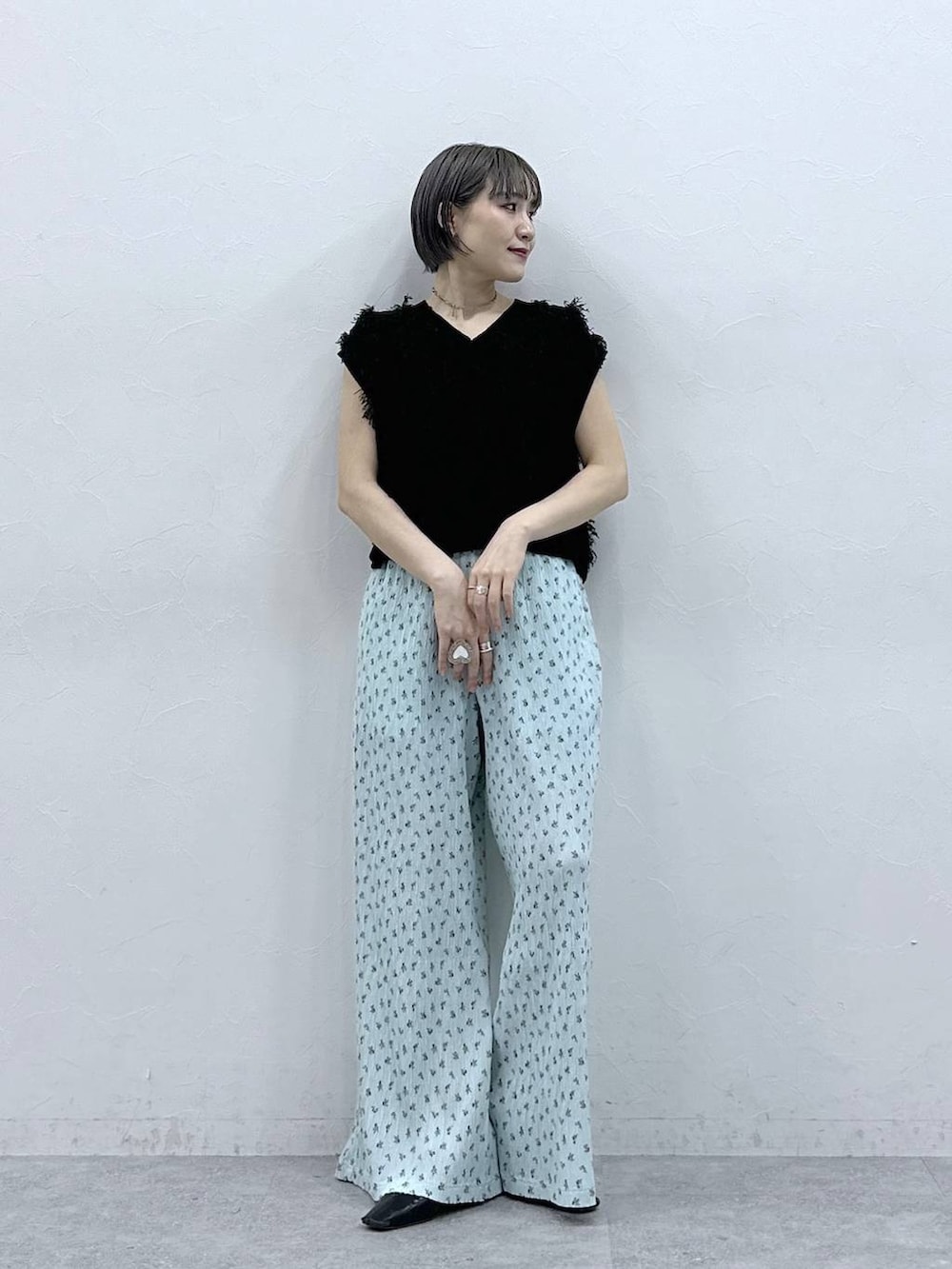 ブルー系のスラックス、ブラック系のベストを着用したレディースの春コーディネートの4枚目の写真