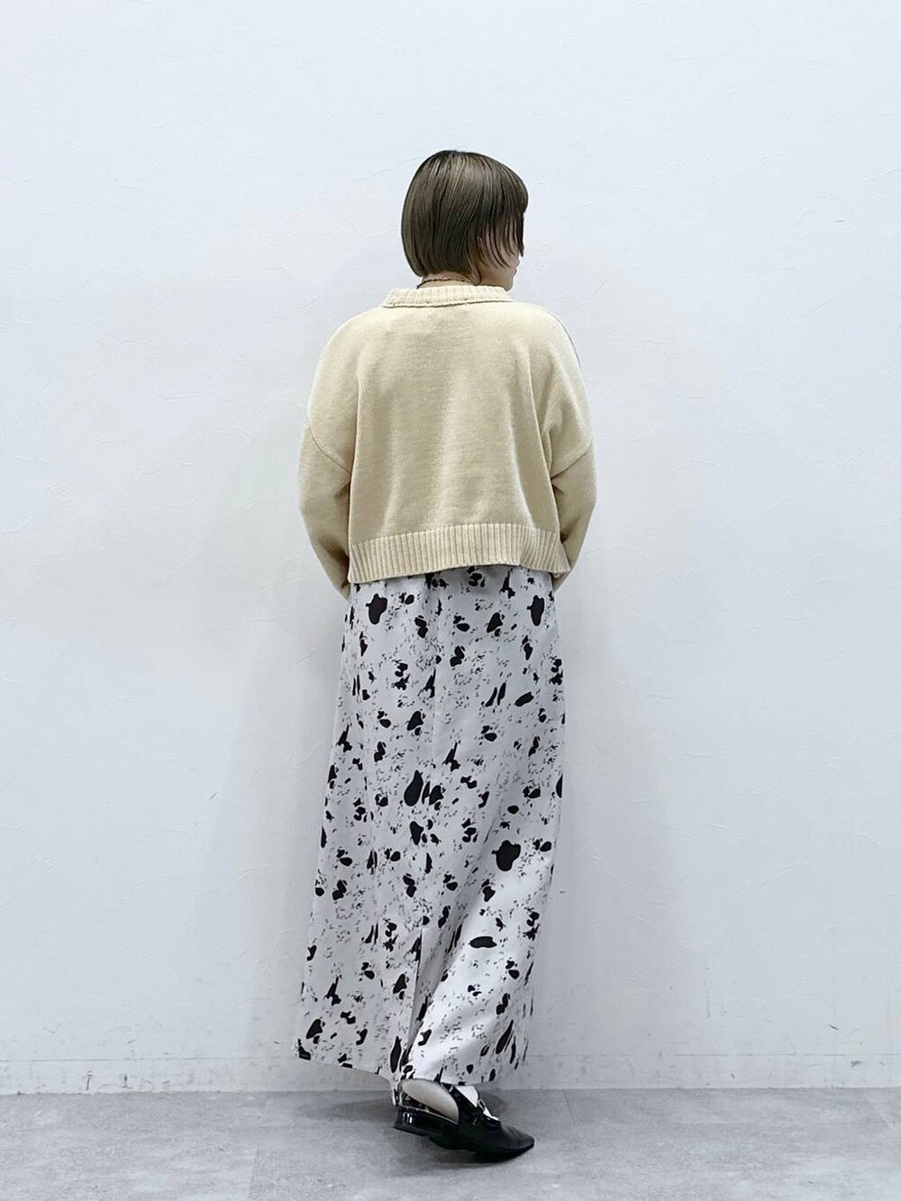 ホワイト系のニット/セーター、ブラウン系のスカート、ブラック系のパンプスを着用したレディースの冬コーディネートの5枚目の写真