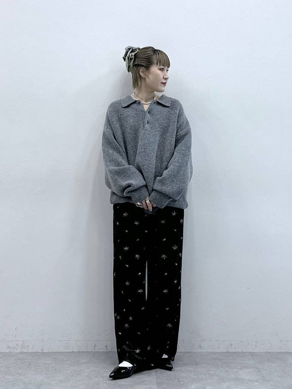 ブラック系のスウェットパンツ、グレー系のポロシャツ、ブラック系のパンプスを着用したレディースの冬コーディネートの3枚目の写真
