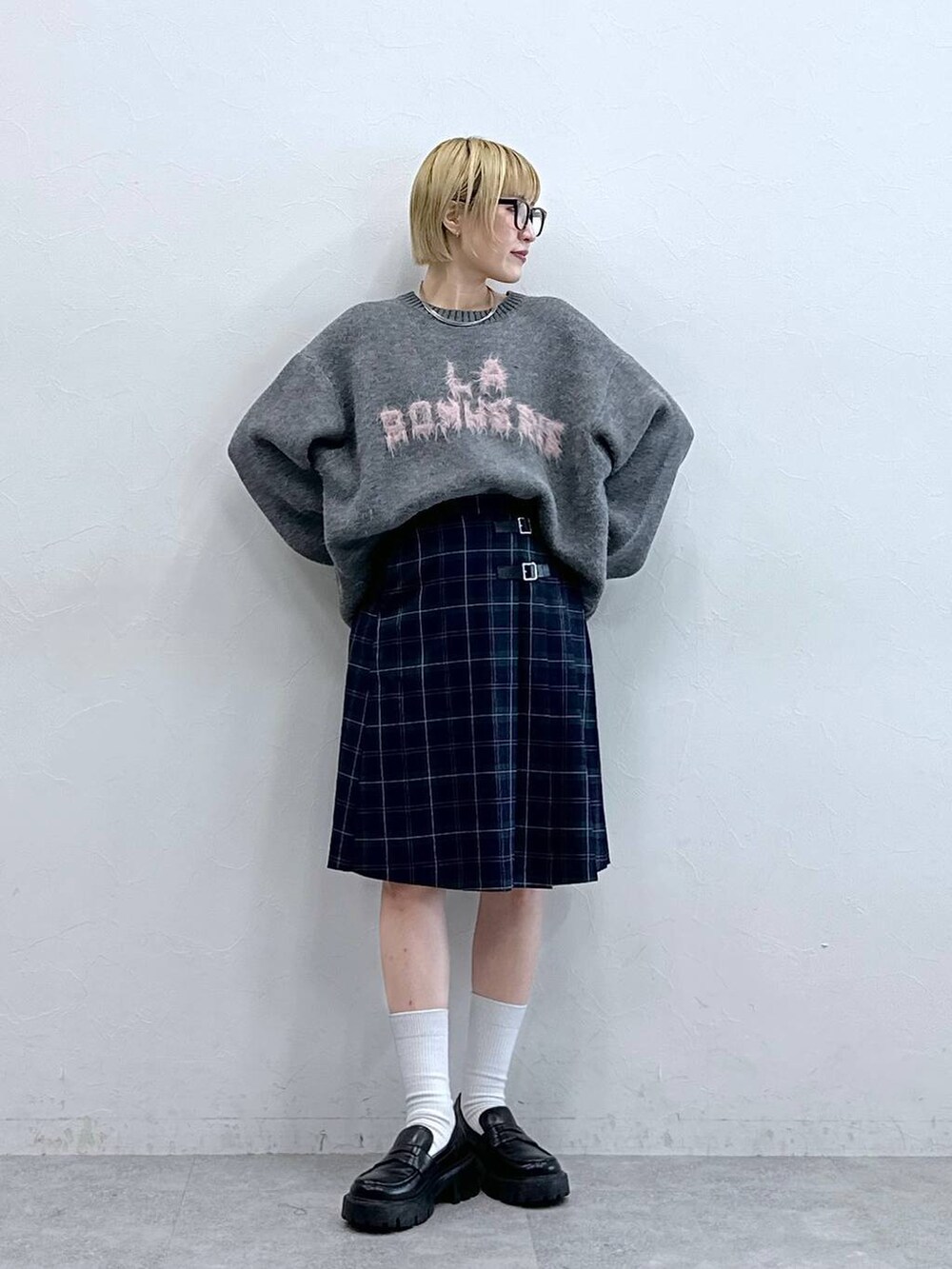 ブラック系のローファー、グレー系のニット/セーター、グリーン系のスカートを着用したレディースの秋コーディネートの3枚目の写真