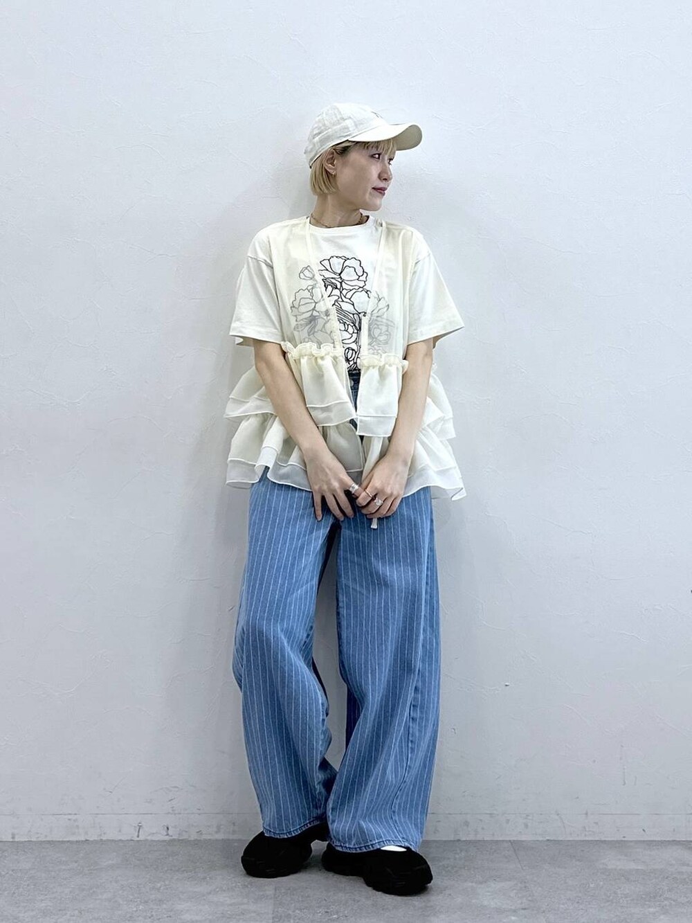 ブラック系のサンダル、ホワイト系のTシャツ/カットソー、ホワイト系のベストを着用したレディースの春コーディネートの3枚目の写真