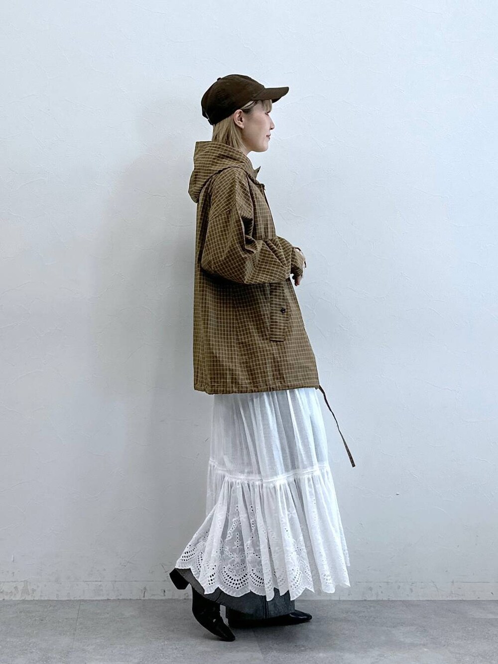 ブラック系のデニムパンツ、イエロー系のシャツ/ブラウス、ホワイト系のスカートを着用したレディースの夏コーディネートの4枚目の写真