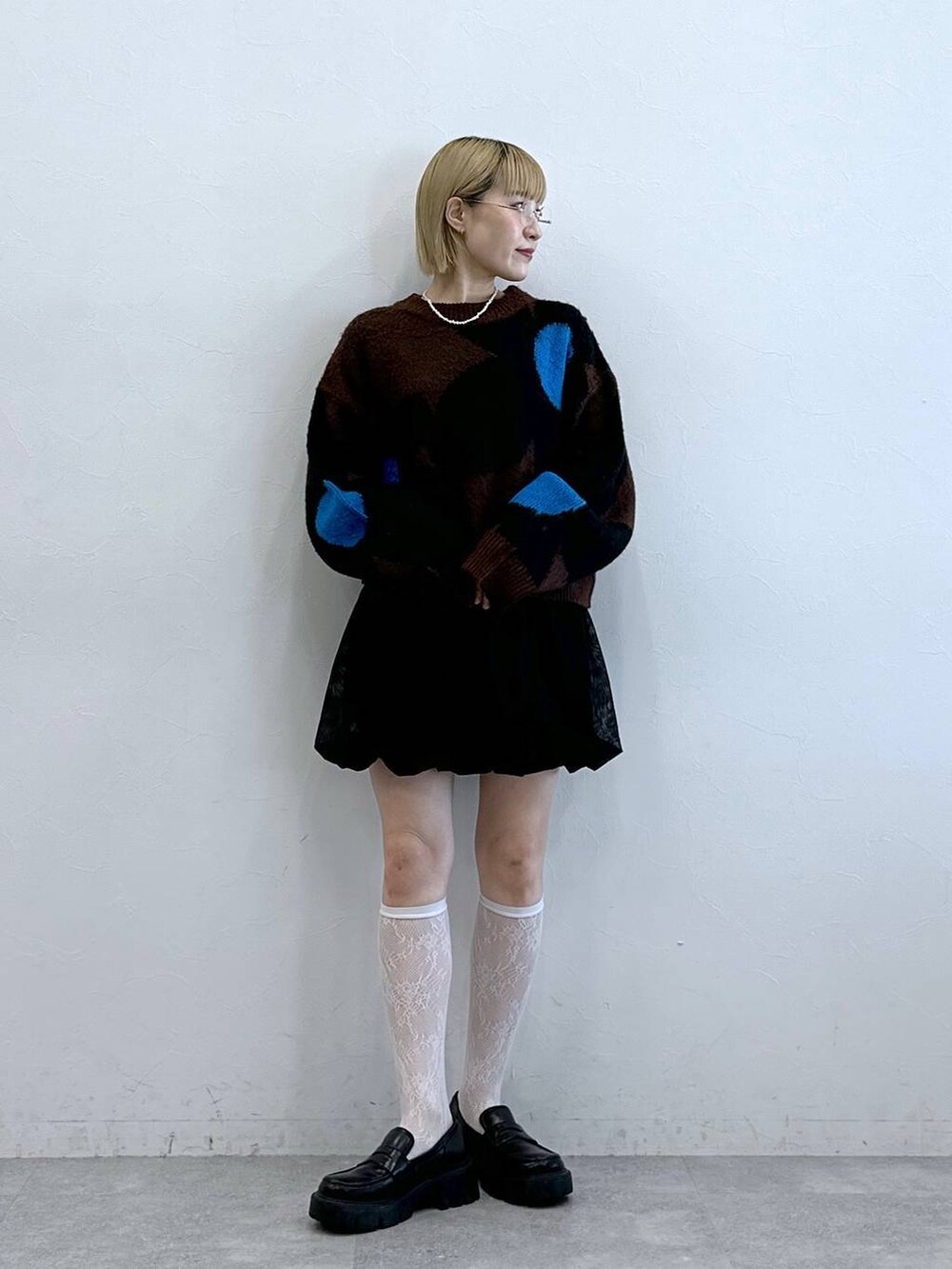 ブラック系のローファー、ブラック系のスカート、ブラウン系のニット/セーターを着用したレディースの夏コーディネートの4枚目の写真