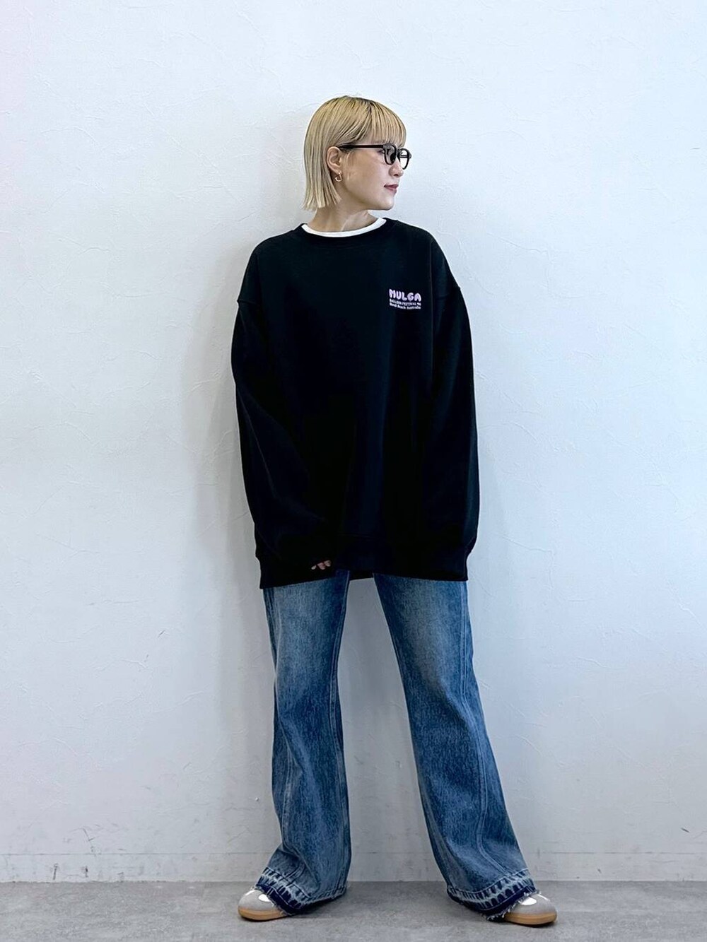 ブルー系のデニムパンツ、ブラック系のスウェット、ブラック系のサングラスを着用したレディースの秋コーディネートの4枚目の写真