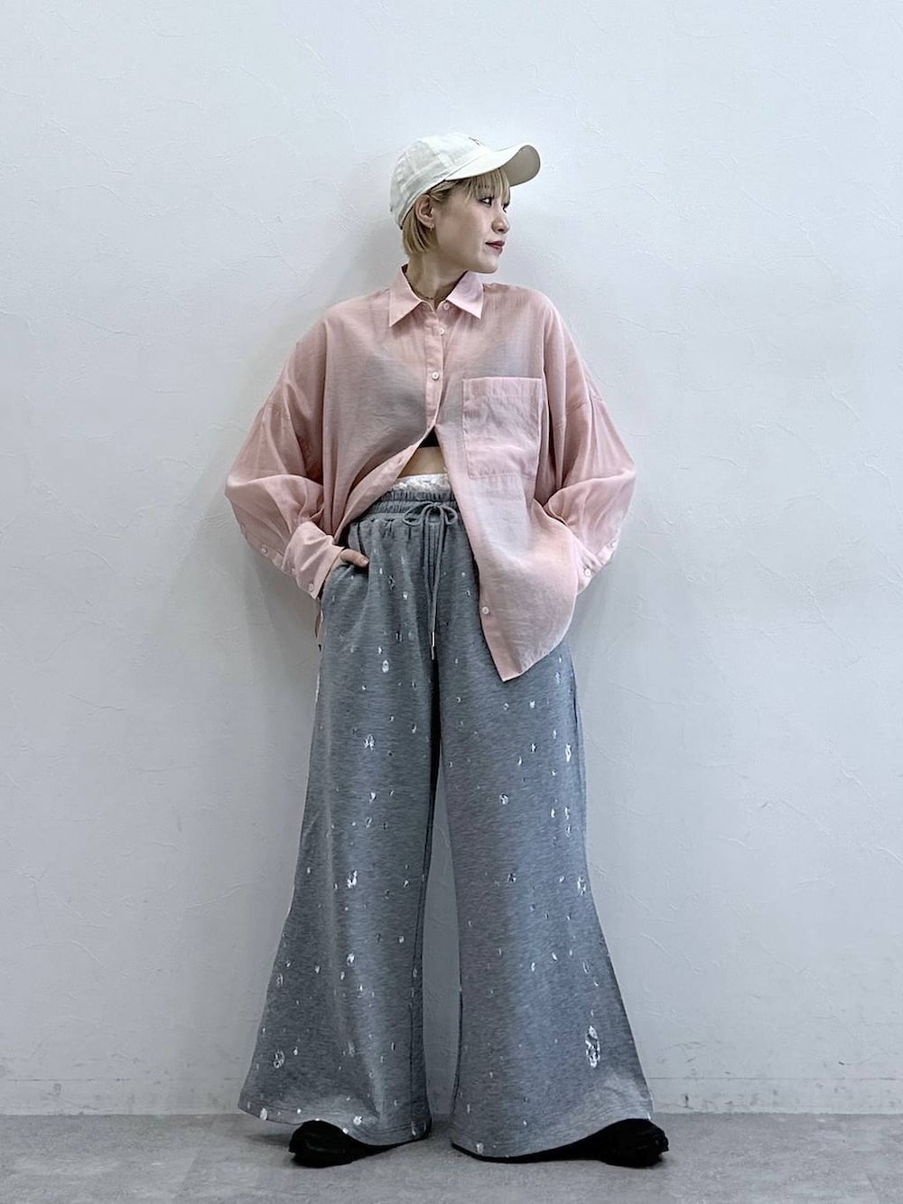 ピンク系のシャツ/ブラウス、グレー系のスウェットパンツ、ホワイト系のキャップを着用したレディースの春コーディネートの2枚目の写真