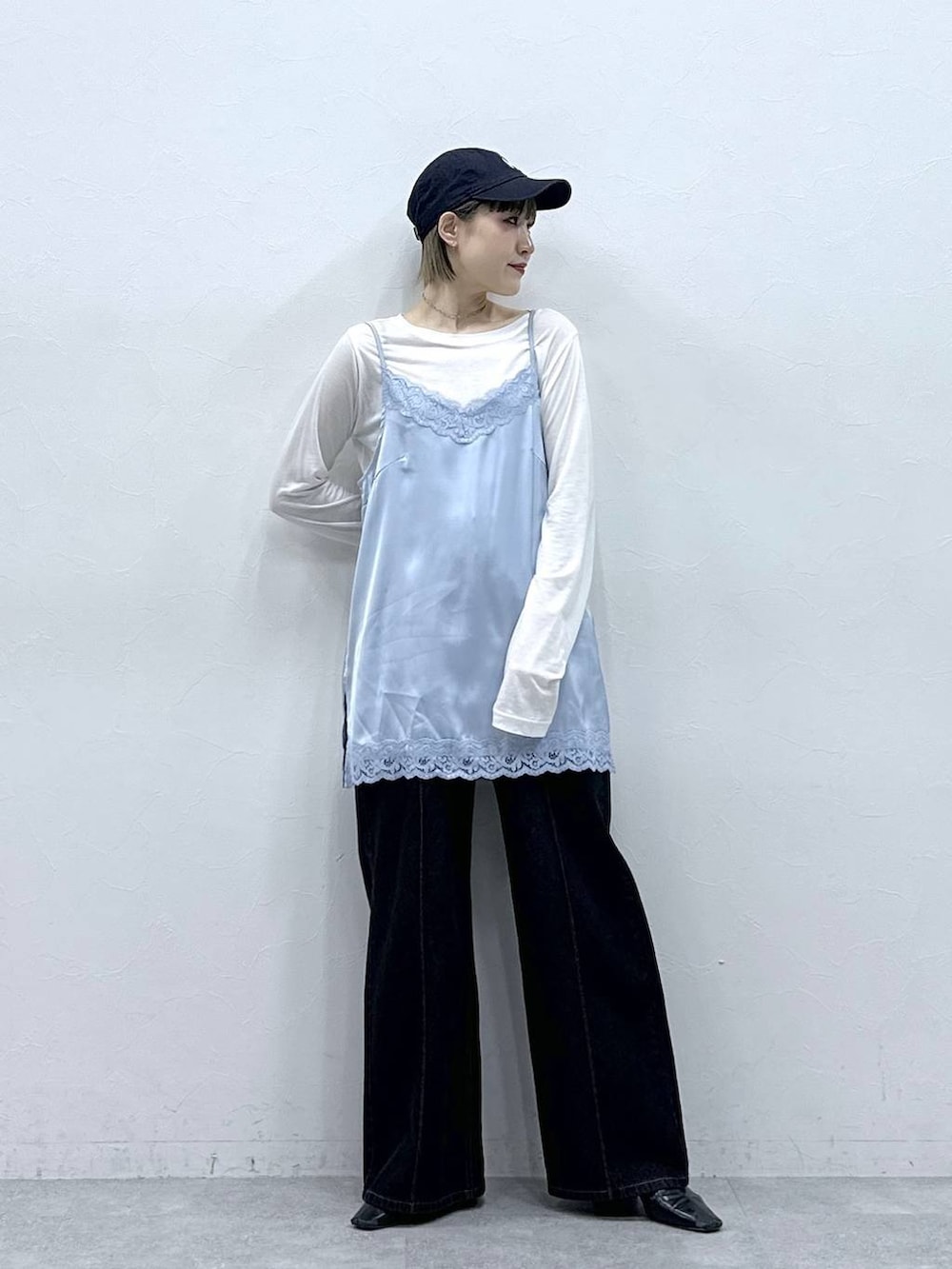 ブラック系のデニムパンツ、ブルー系のキャミソール、ホワイト系のTシャツ/カットソーを着用したレディースの冬コーディネートの3枚目の写真