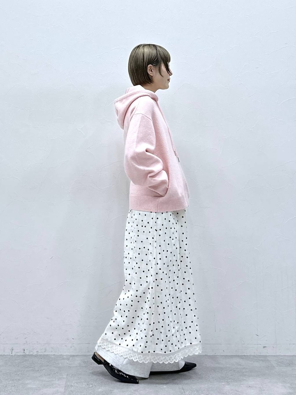 ホワイト系のTシャツ/カットソー、ブラック系のパンプス、ピンク系のニット/セーターを着用したレディースの冬コーディネートの4枚目の写真