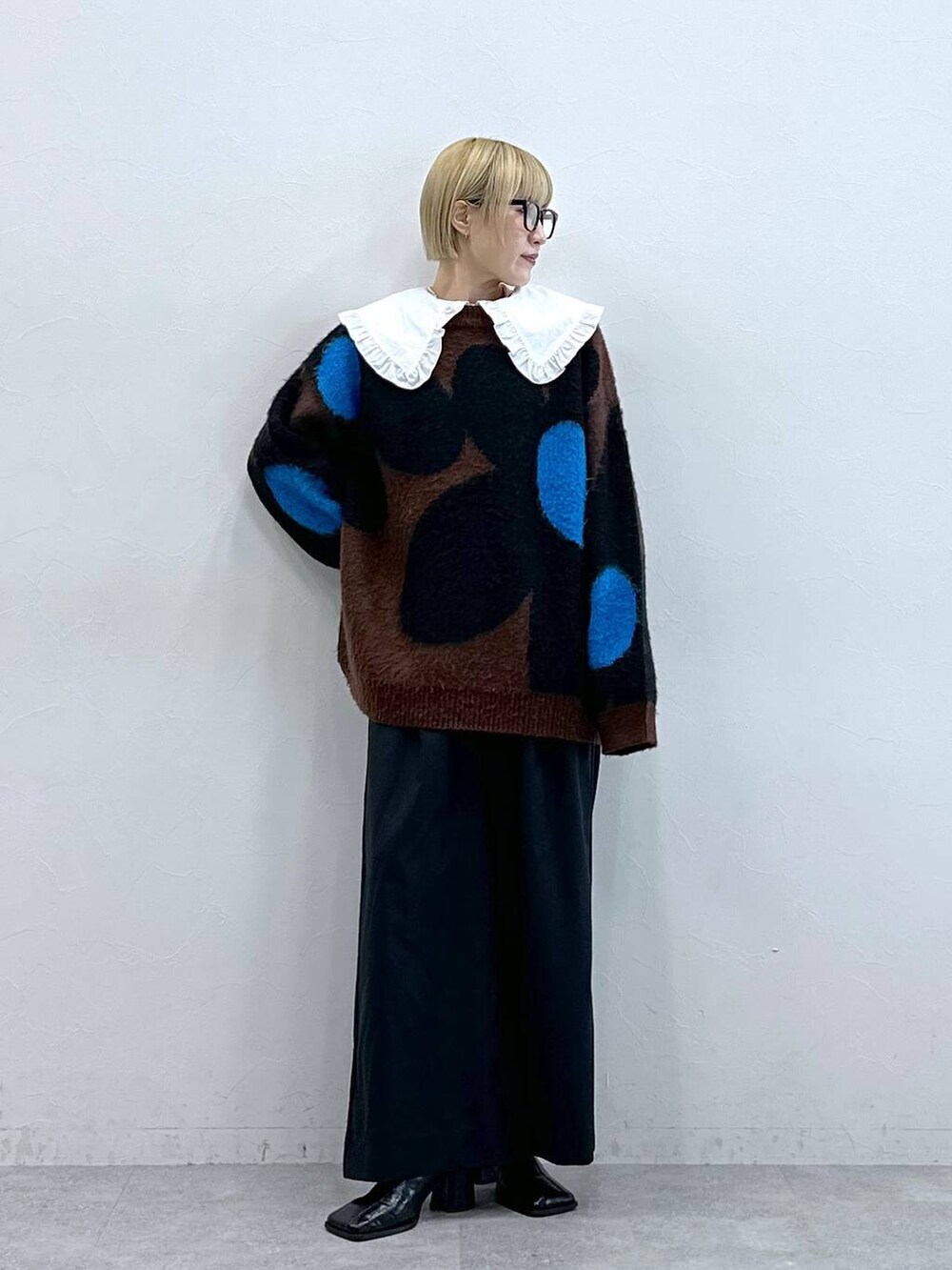 ブラック系のテーラードジャケット、ブラウン系のニット/セーター、ホワイト系のシャツ/ブラウスを着用したレディースの秋コーディネートの4枚目の写真