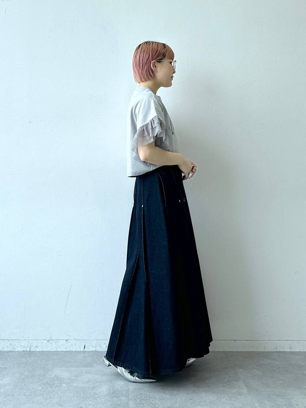 ブルー系のデニムスカート、グレー系のTシャツ/カットソー、ブラック系のメガネを着用したレディースの春コーディネートの5枚目の写真