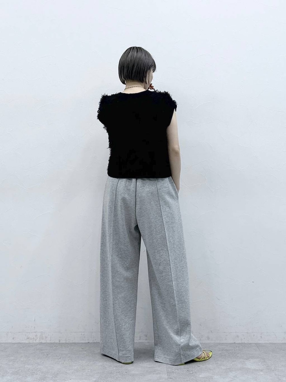 グレー系のスウェットパンツ、ブラック系のベストを着用したレディースの春コーディネートの6枚目の写真