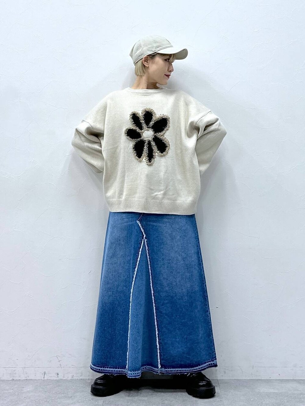 ブルー系のデニムスカート、ホワイト系のニット/セーター、ブラック系のローファーを着用したレディースの冬コーディネートの3枚目の写真