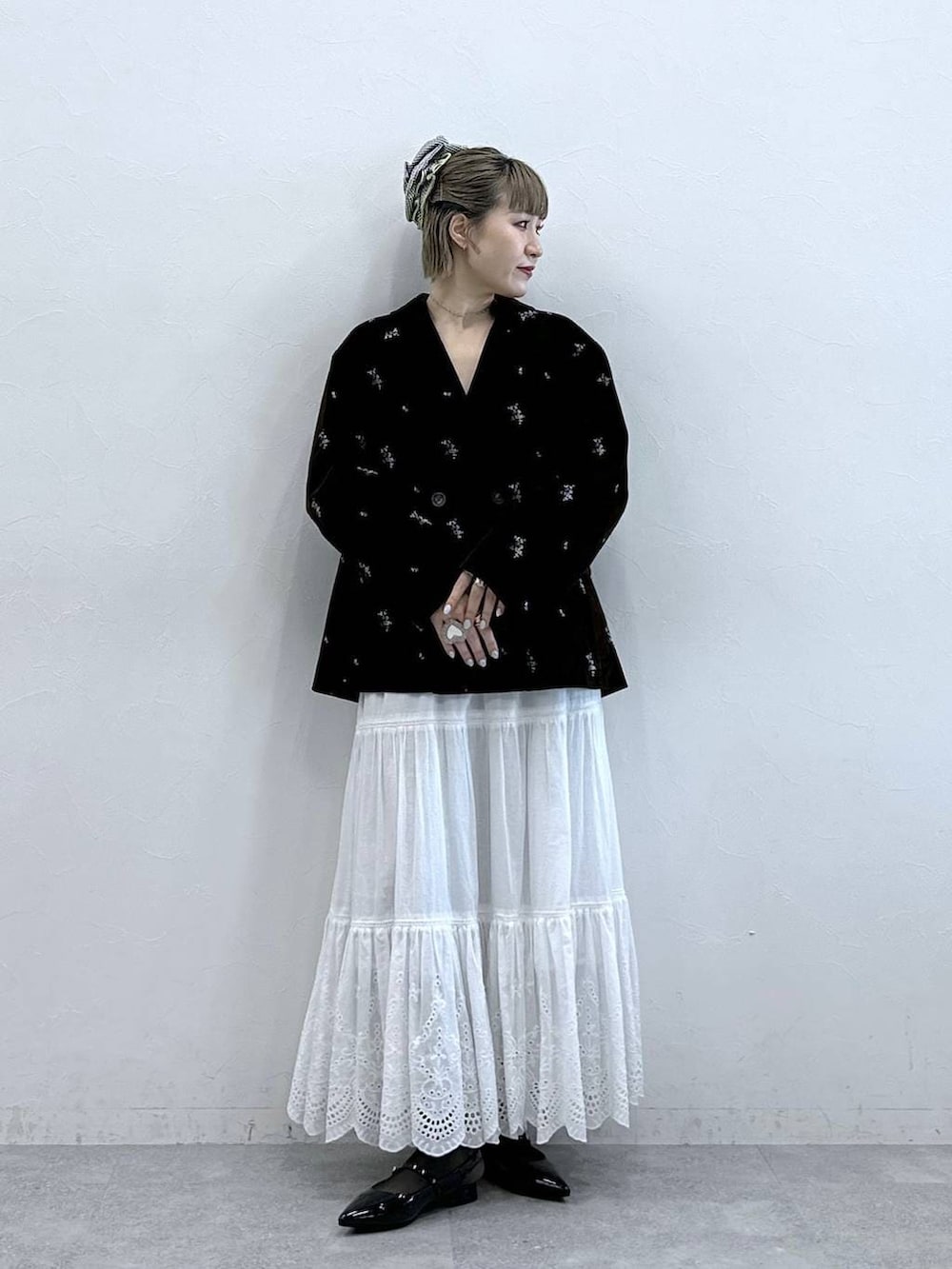 ブラック系のパンプス、ブラック系のテーラードジャケット、ホワイト系のスカートを着用したレディースの冬コーディネートの3枚目の写真