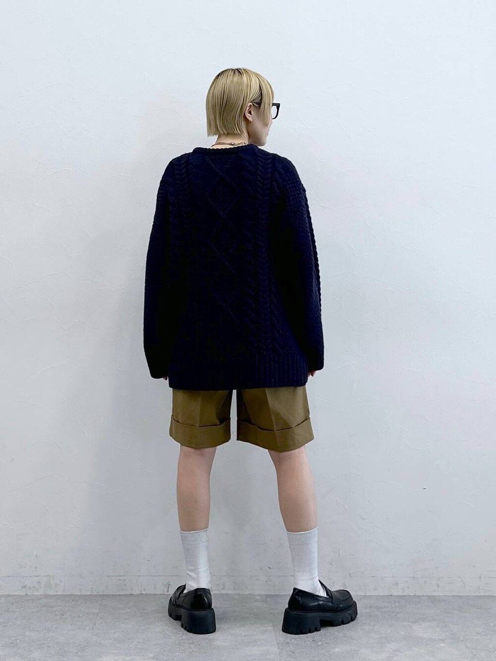 ブラック系のローファー、ブラウン系のチノパンツ、ブルー系のニット/セーターを着用したレディースの秋コーディネートの5枚目の写真