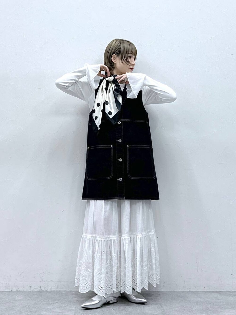 シルバー系のパンプス、ブラック系のワンピース、ホワイト系のTシャツ/カットソーを着用したレディースの冬コーディネートの3枚目の写真