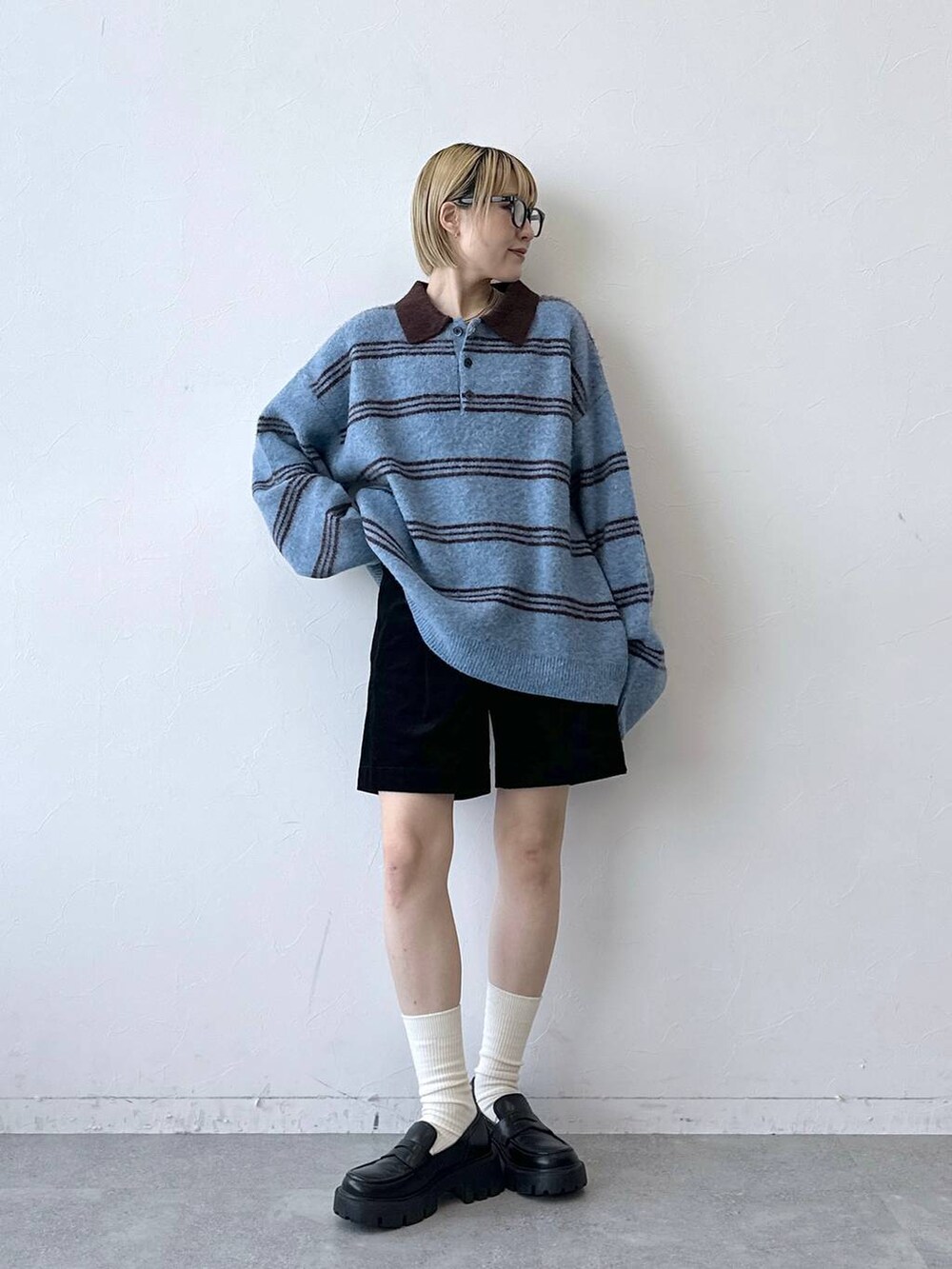 ブラック系のローファー、ブラック系のその他パンツ、ブルー系のポロシャツを着用したレディースの秋コーディネートの2枚目の写真