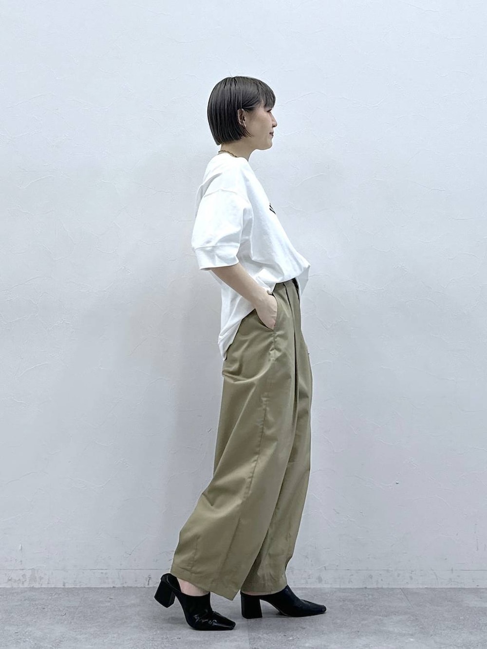 ベージュ系のチノパンツ、ホワイト系のTシャツ/カットソーを着用したレディースの春コーディネートの5枚目の写真