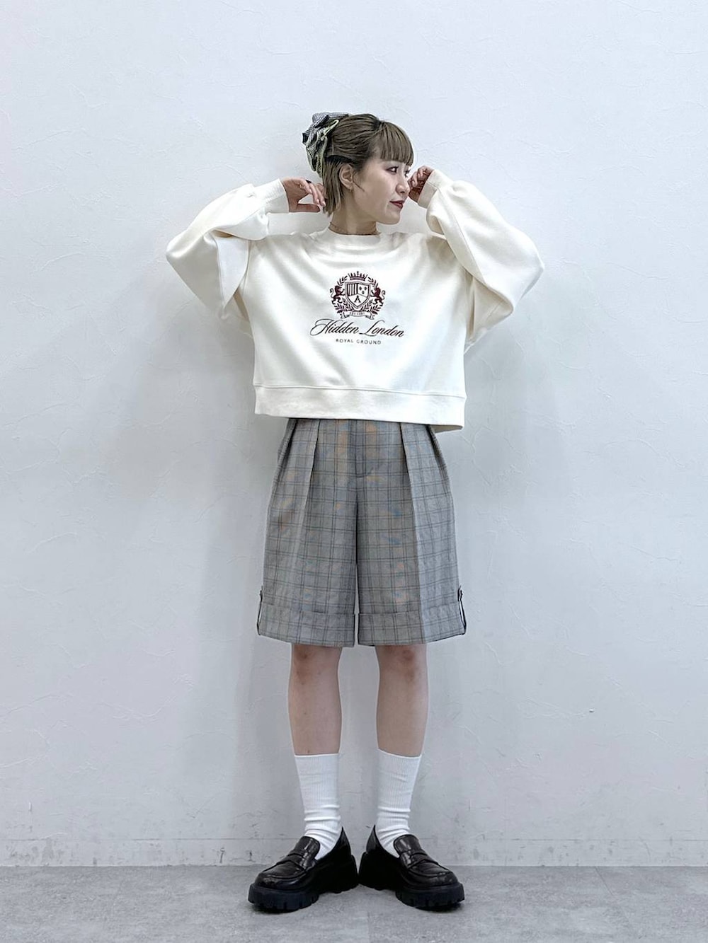 ブラック系のローファー、ホワイト系のスウェット、ベージュ系のスラックスを着用したレディースの冬コーディネートの2枚目の写真