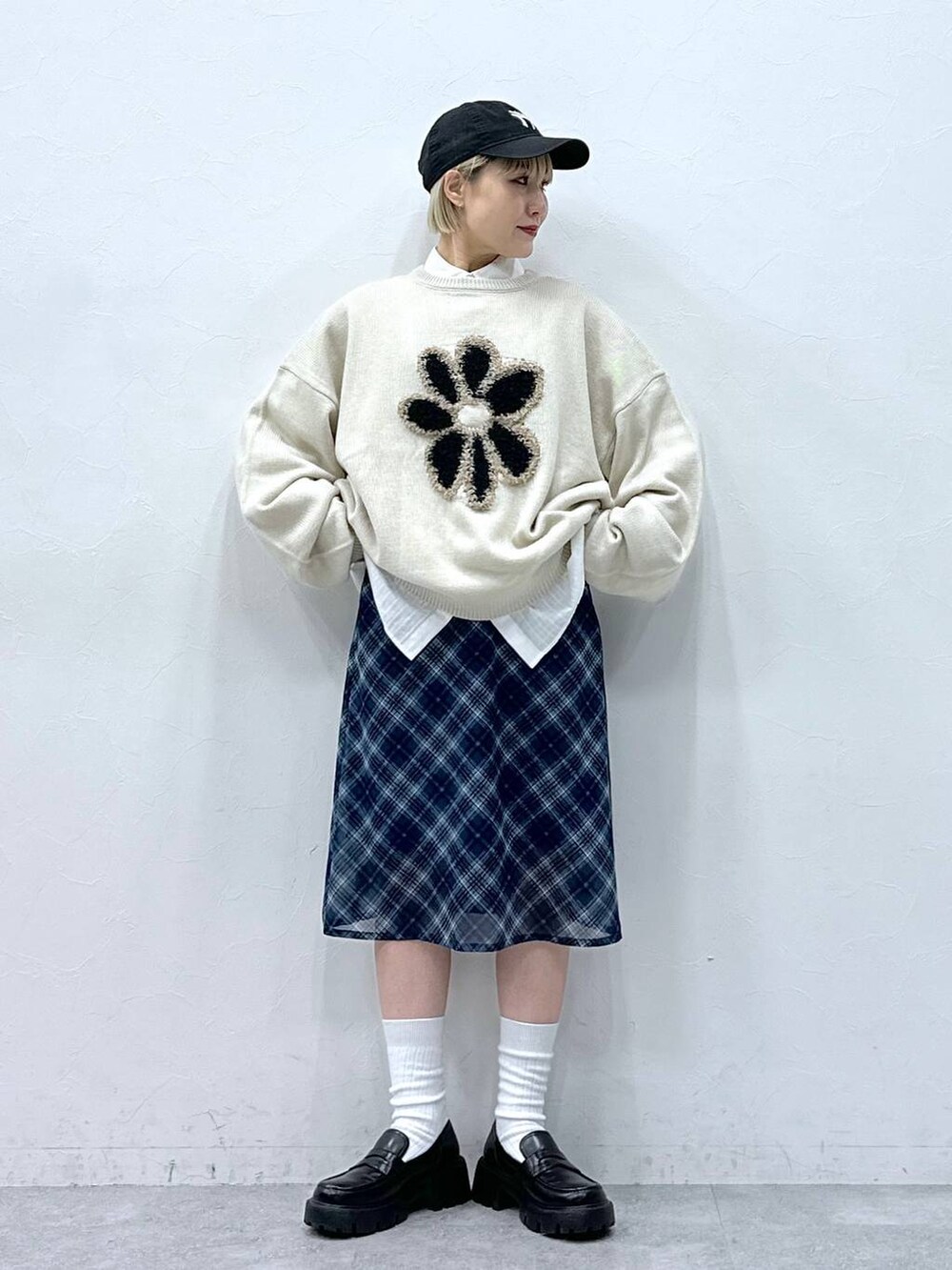 ホワイト系のニット/セーター、ホワイト系のシャツ/ブラウス、ブラック系のローファーを着用したレディースの冬コーディネートの2枚目の写真