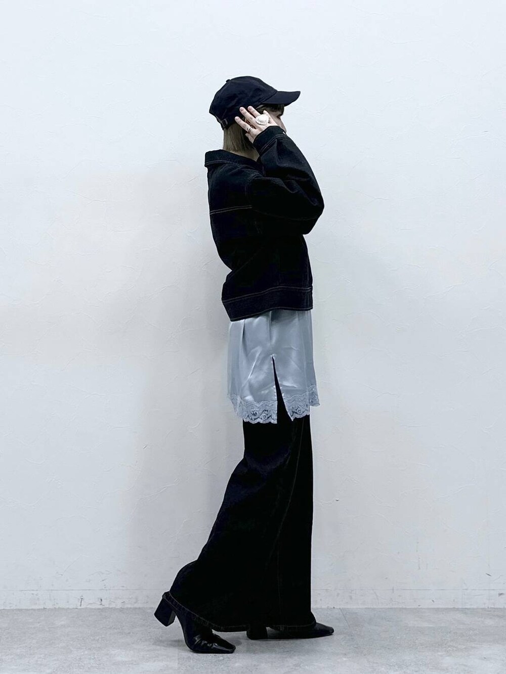 ブラック系のデニムジャケット、ブラック系のデニムパンツ、ブルー系のキャミソールを着用したレディースの冬コーディネートの4枚目の写真