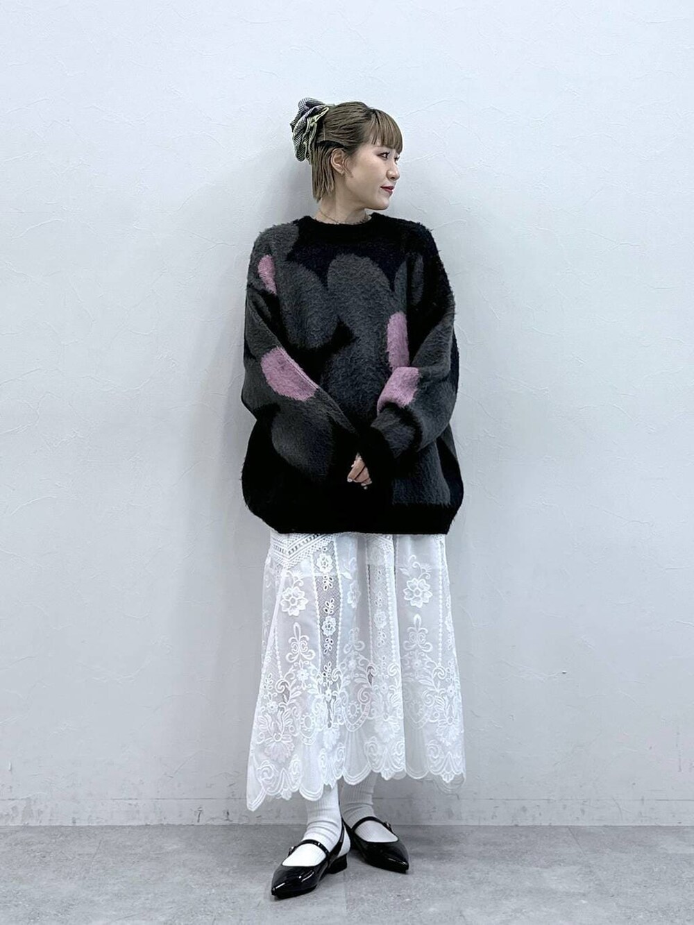 ブラック系のニット/セーター、ホワイト系のスカート、ブラック系のパンプスを着用したレディースの冬コーディネートの2枚目の写真