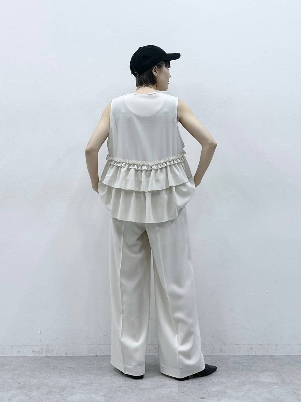 グレー系のタンクトップ、ブラック系のキャップを着用したレディースの春コーディネートの7枚目の写真