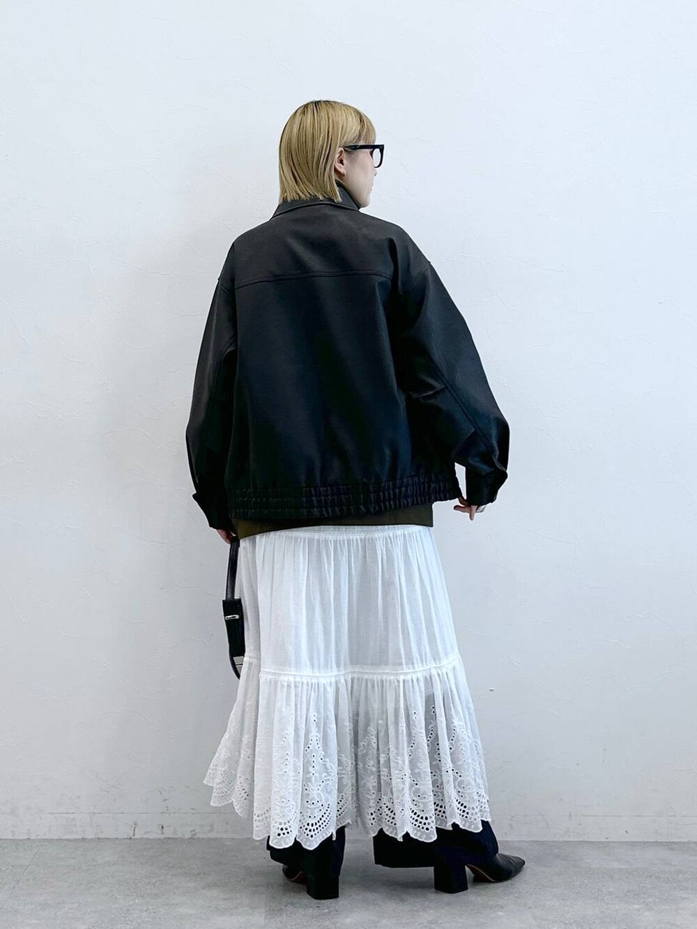 その他のスラックス、ブラック系のブルゾン、ホワイト系のスカートを着用したレディースの夏コーディネートの8枚目の写真