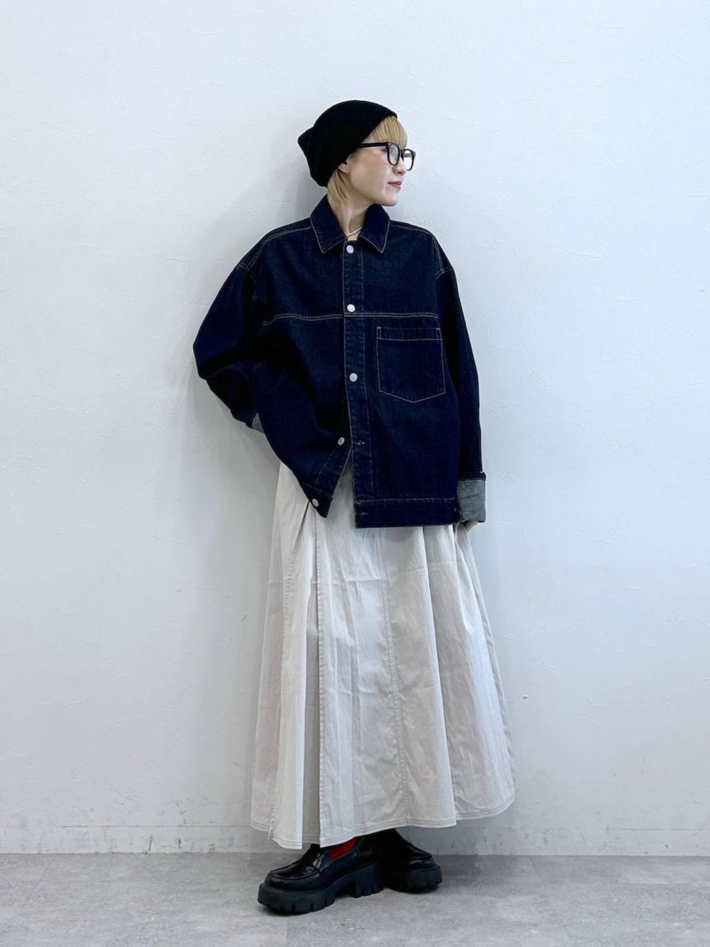 ブラック系のローファー、ブルー系のデニムジャケット、ホワイト系のスカートを着用したレディースの夏コーディネートの2枚目の写真
