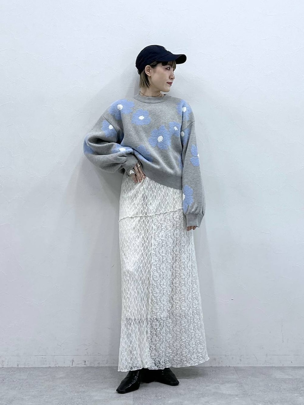 グレー系のニット/セーター、ホワイト系のスカートを着用したレディースの冬コーディネートの3枚目の写真