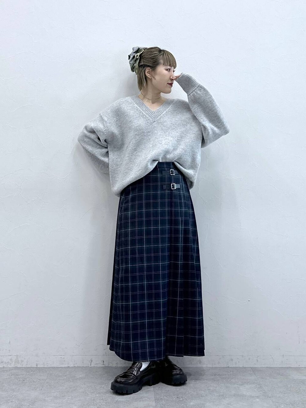 ブラック系のローファー、グリーン系のスカート、グレー系のニット/セーターを着用したレディースの冬コーディネートの2枚目の写真