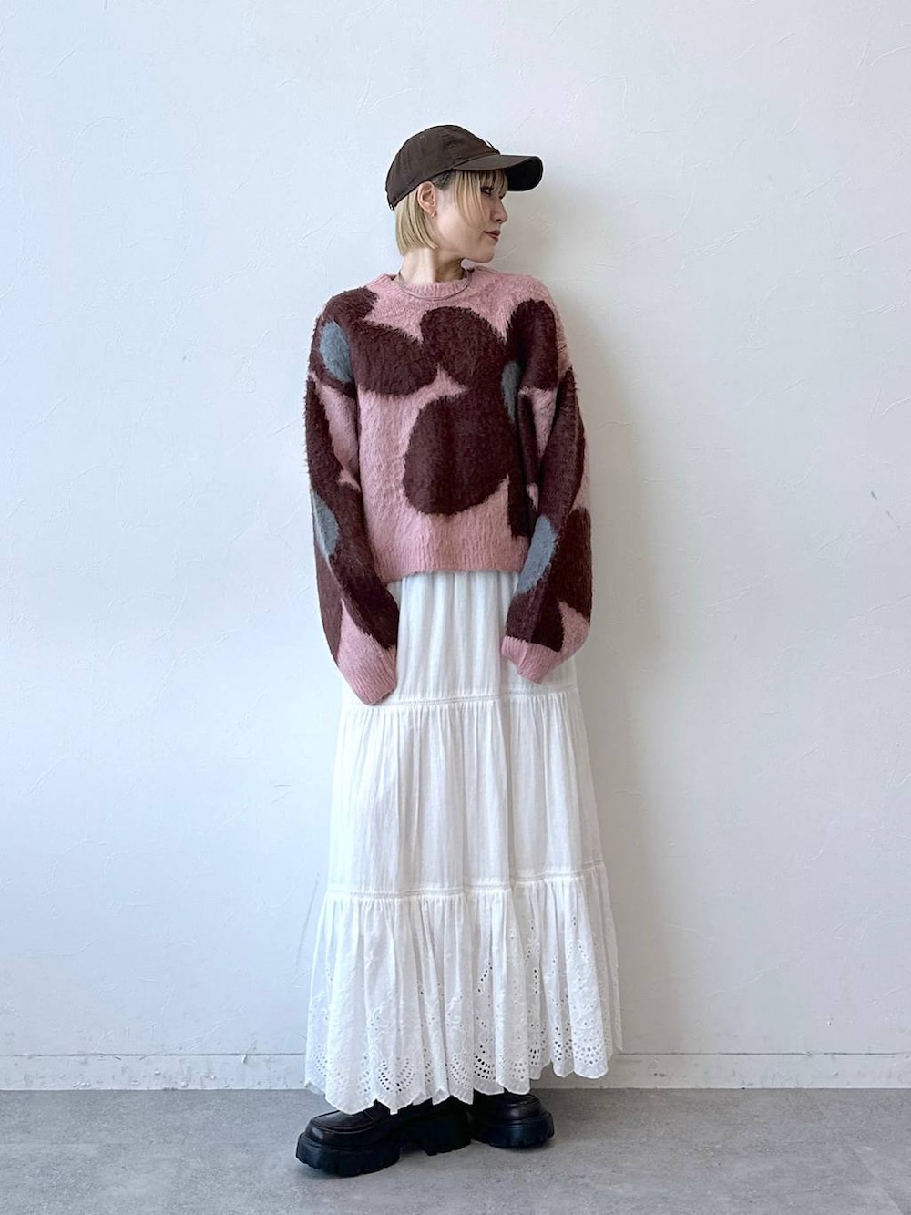 ブラック系のローファー、ピンク系のニット/セーター、ホワイト系のスカートを着用したレディースの秋コーディネートの4枚目の写真