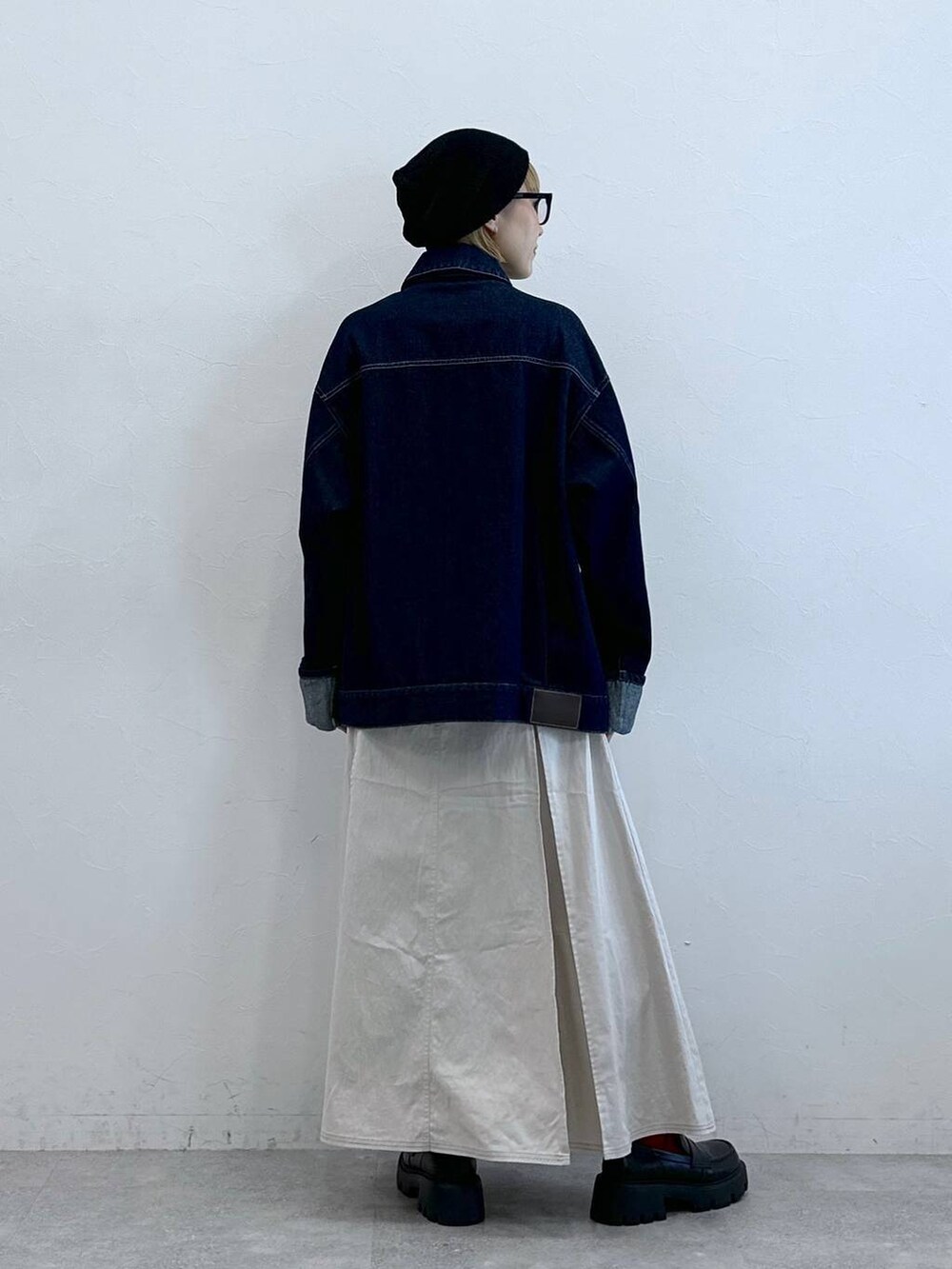 ブラック系のローファー、ブルー系のデニムジャケット、ホワイト系のスカートを着用したレディースの夏コーディネートの7枚目の写真