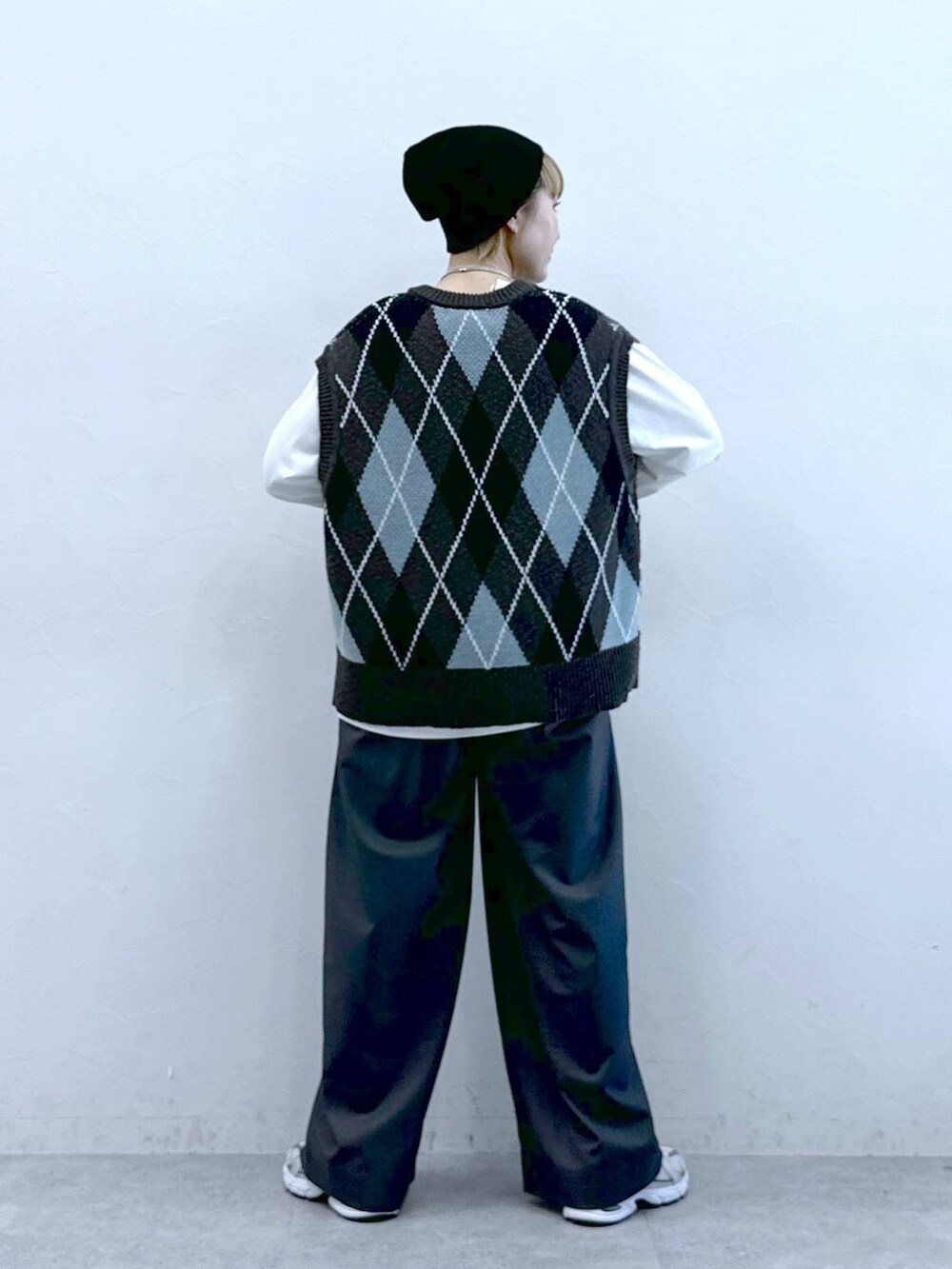 ホワイト系のTシャツ/カットソー、グレー系のスラックス、グレー系のベストを着用したレディースの冬コーディネートの5枚目の写真