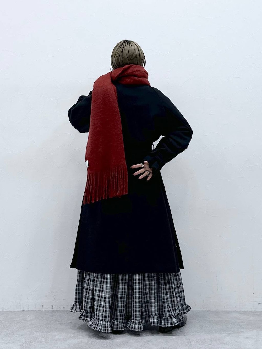 ブラック系のステンカラーコート、ブラック系のスカート、ブラック系のパンプスを着用したレディースの冬コーディネートの5枚目の写真