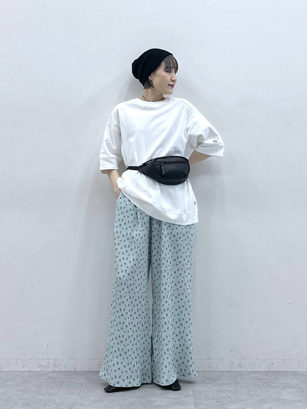 ホワイト系のTシャツ/カットソー、ブラック系のボディバッグ/ウエストポーチ、ブルー系のスラックスを着用したレディースの春コーディネートの3枚目の写真