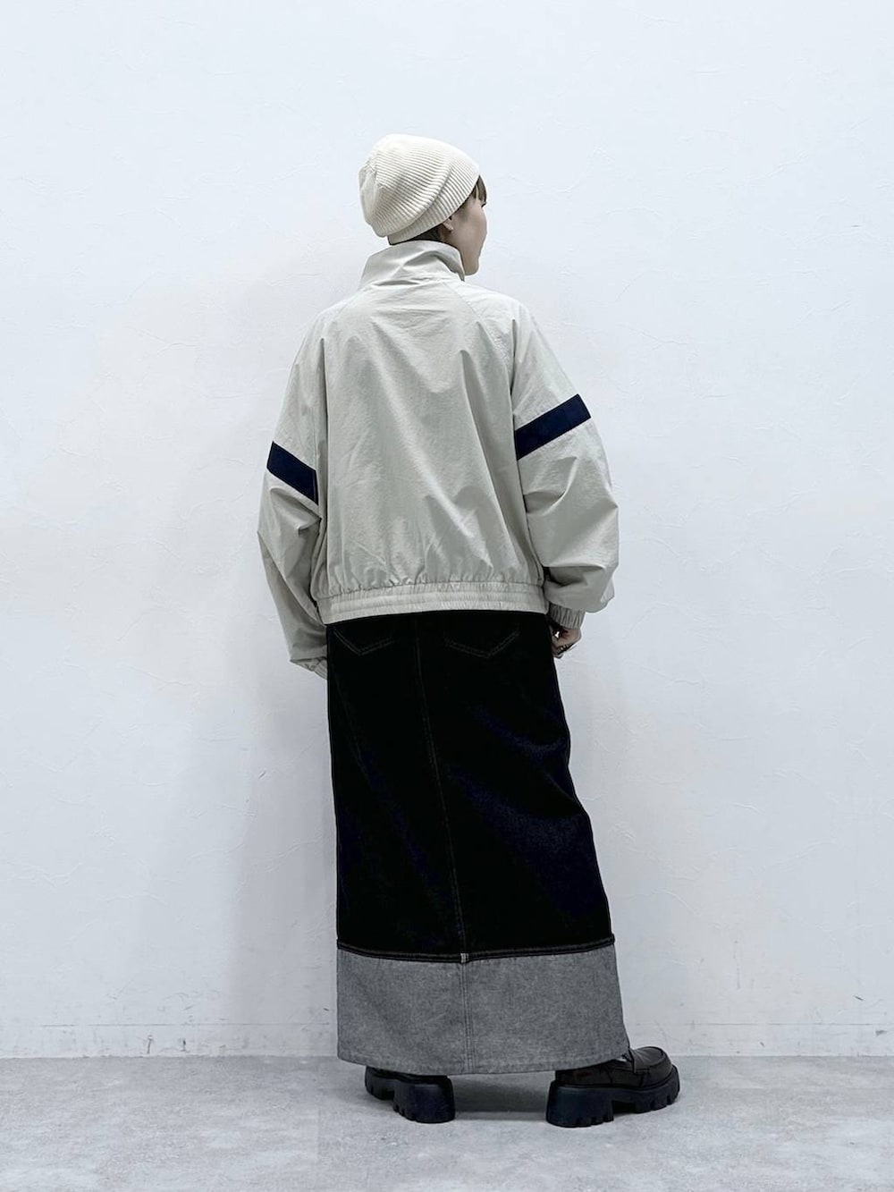 ブラック系のローファー、ホワイト系のブルゾン、ブラック系のデニムスカートを着用したレディースの冬コーディネートの6枚目の写真