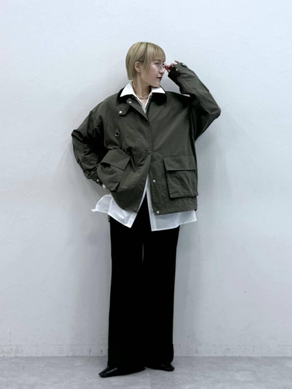 ホワイト系のシャツ/ブラウス、ブラウン系のスラックスを着用したレディースの冬コーディネートの2枚目の写真