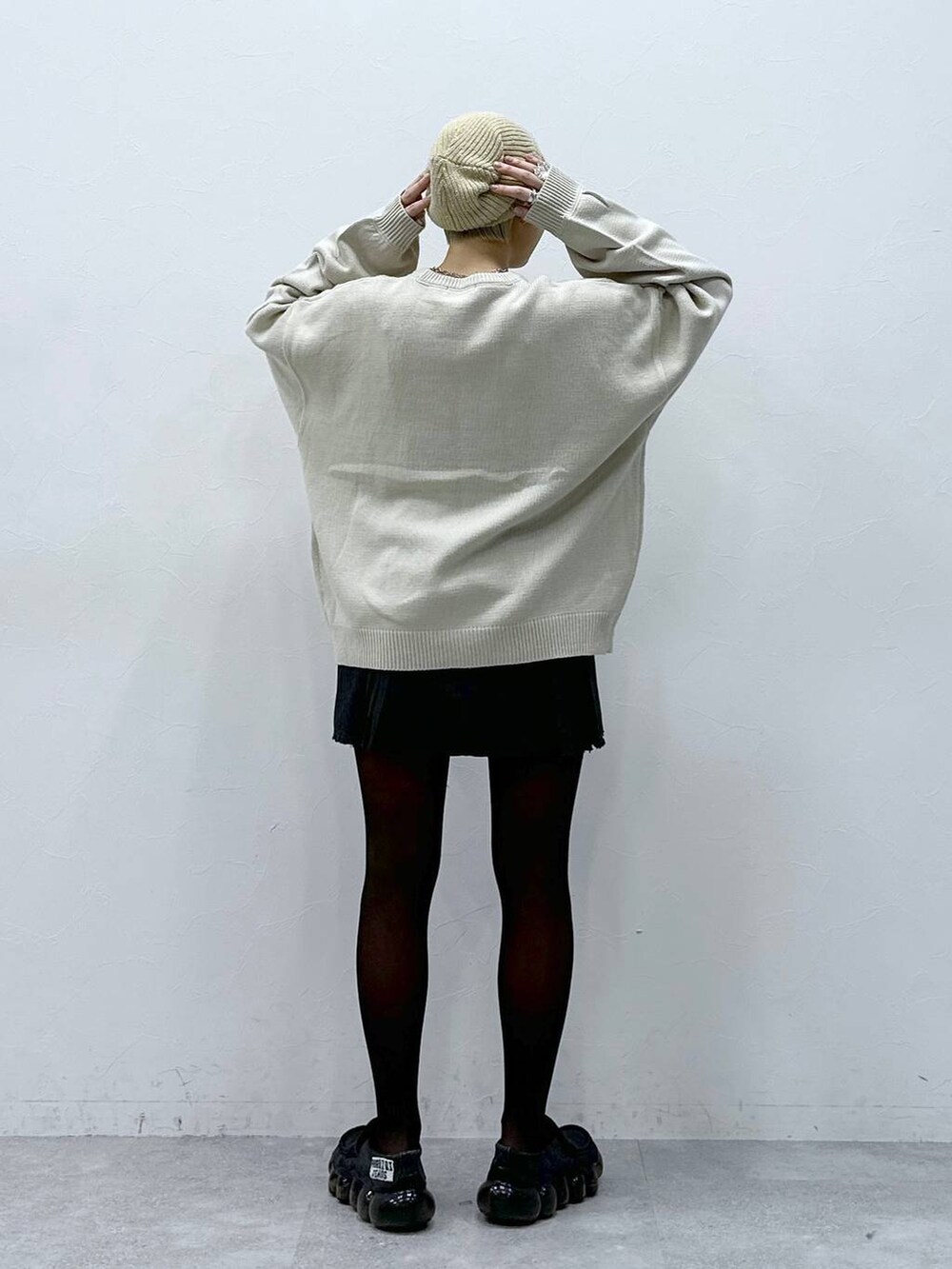 グレー系のスカート、ホワイト系のニット/セーター、ベージュ系のハンチング/ベレー帽を着用したレディースの冬コーディネートの5枚目の写真