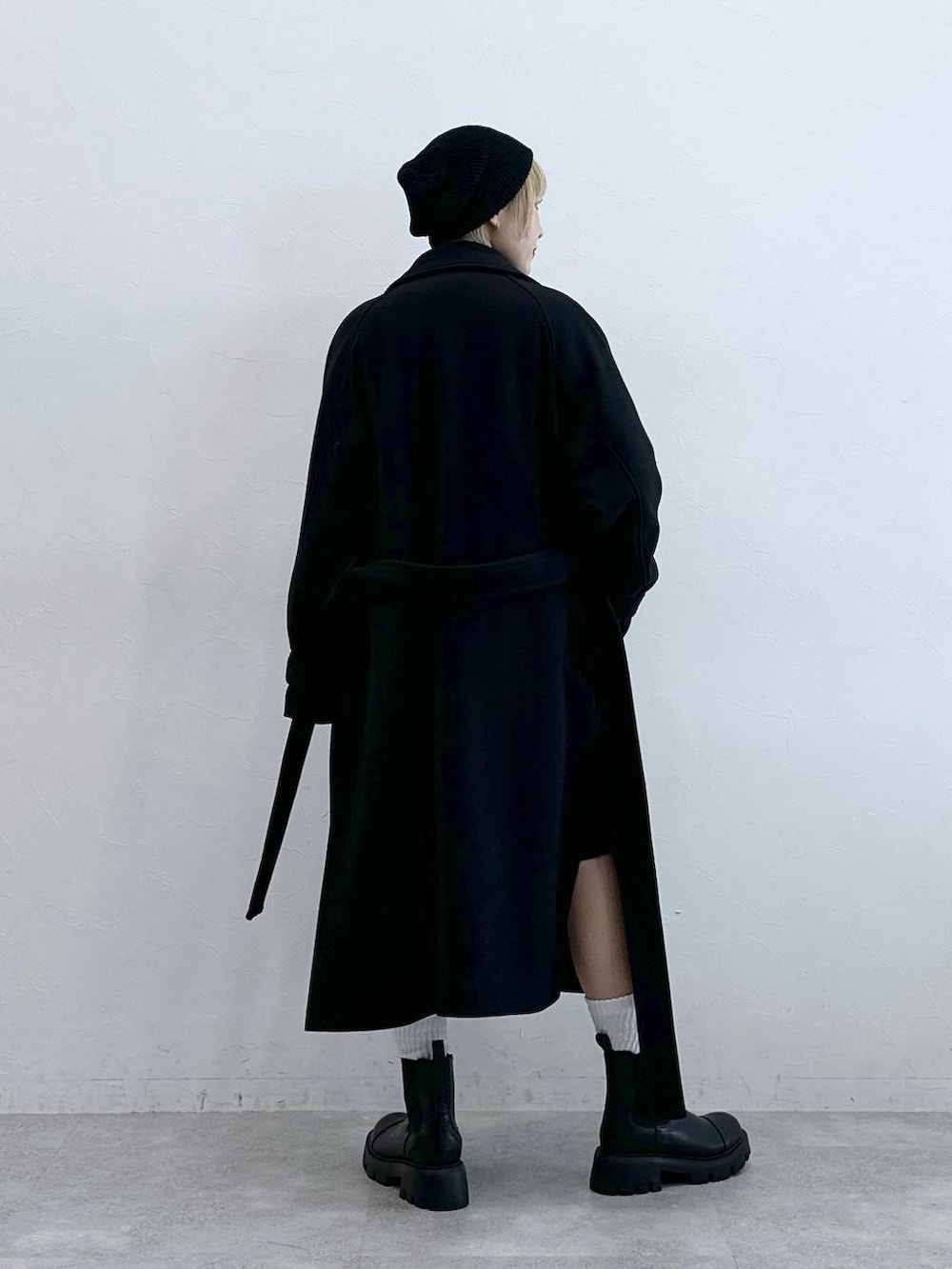 ブラック系のスラックス、イエロー系のニット/セーター、ブラック系のブーツを着用したレディースの秋コーディネートの7枚目の写真