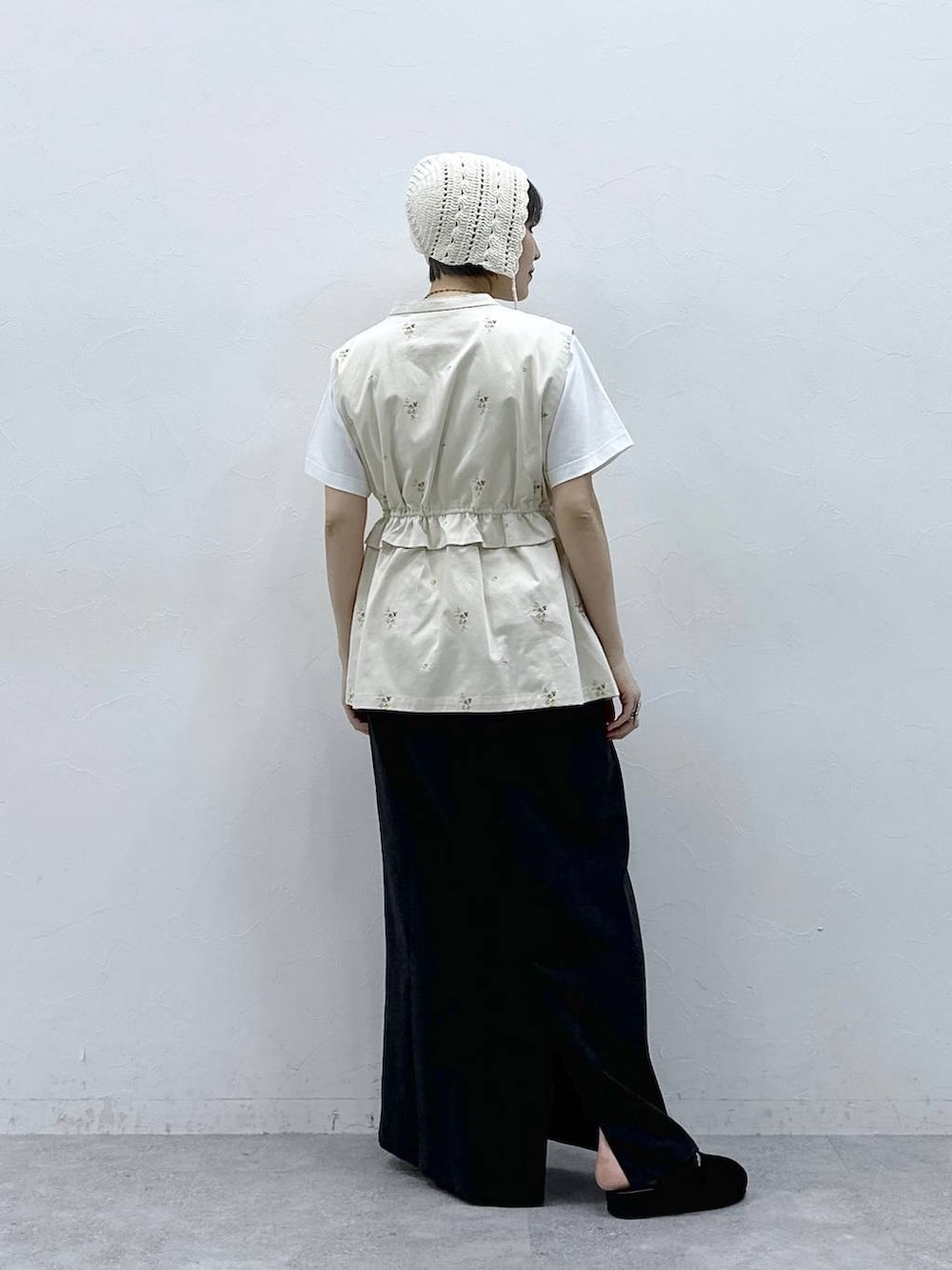 ブラック系のモカシン/デッキシューズ、ブラック系のスカート、ホワイト系のTシャツ/カットソーを着用したレディースの春コーディネートの6枚目の写真