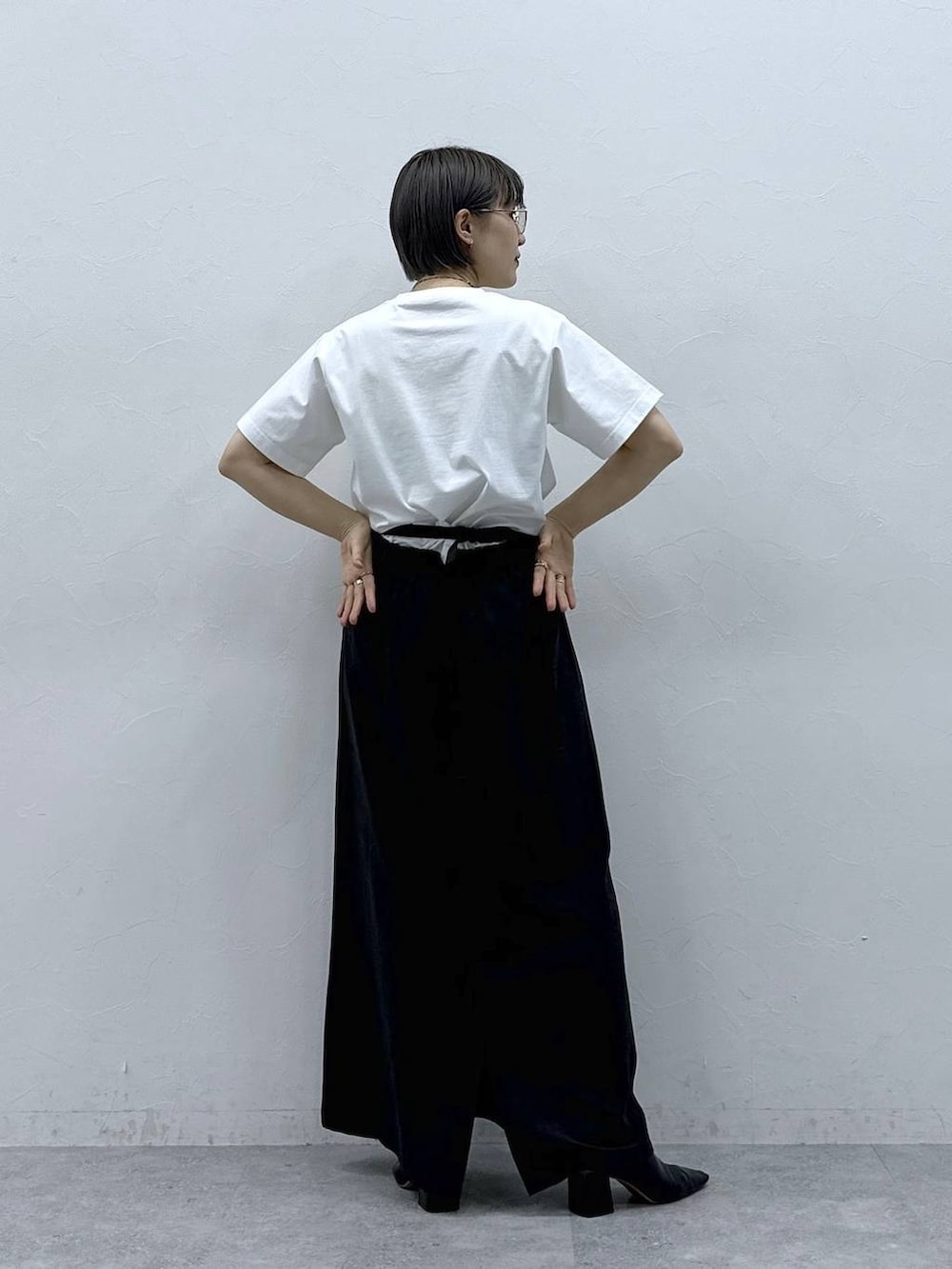 ブラック系のボディバッグ/ウエストポーチ、ブラック系のスカート、ホワイト系のTシャツ/カットソーを着用したレディースの春コーディネートの7枚目の写真