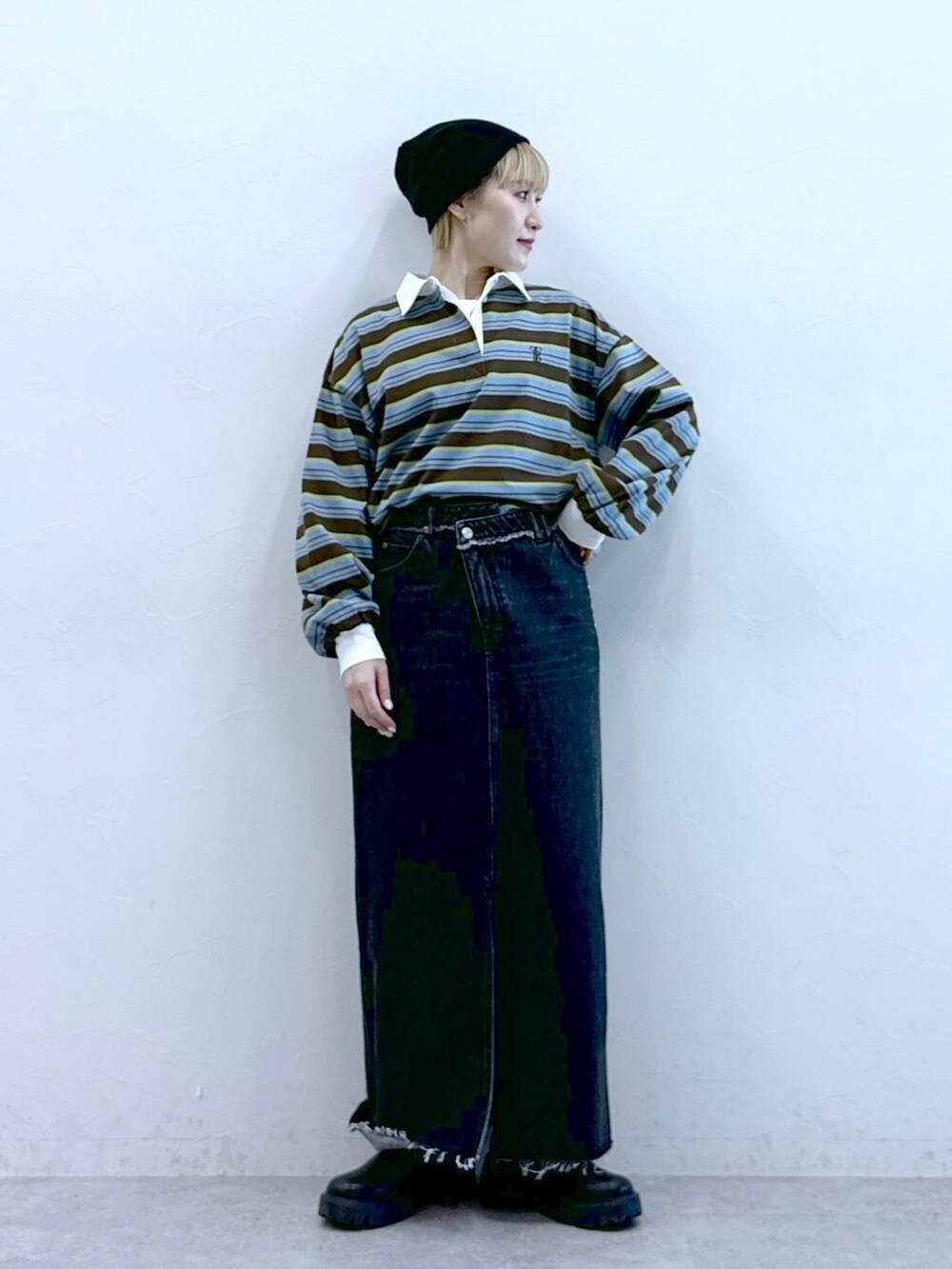 ブラック系のブーツ、ブラック系のデニムスカート、ブラウン系のポロシャツを着用したレディースの冬コーディネートの7枚目の写真