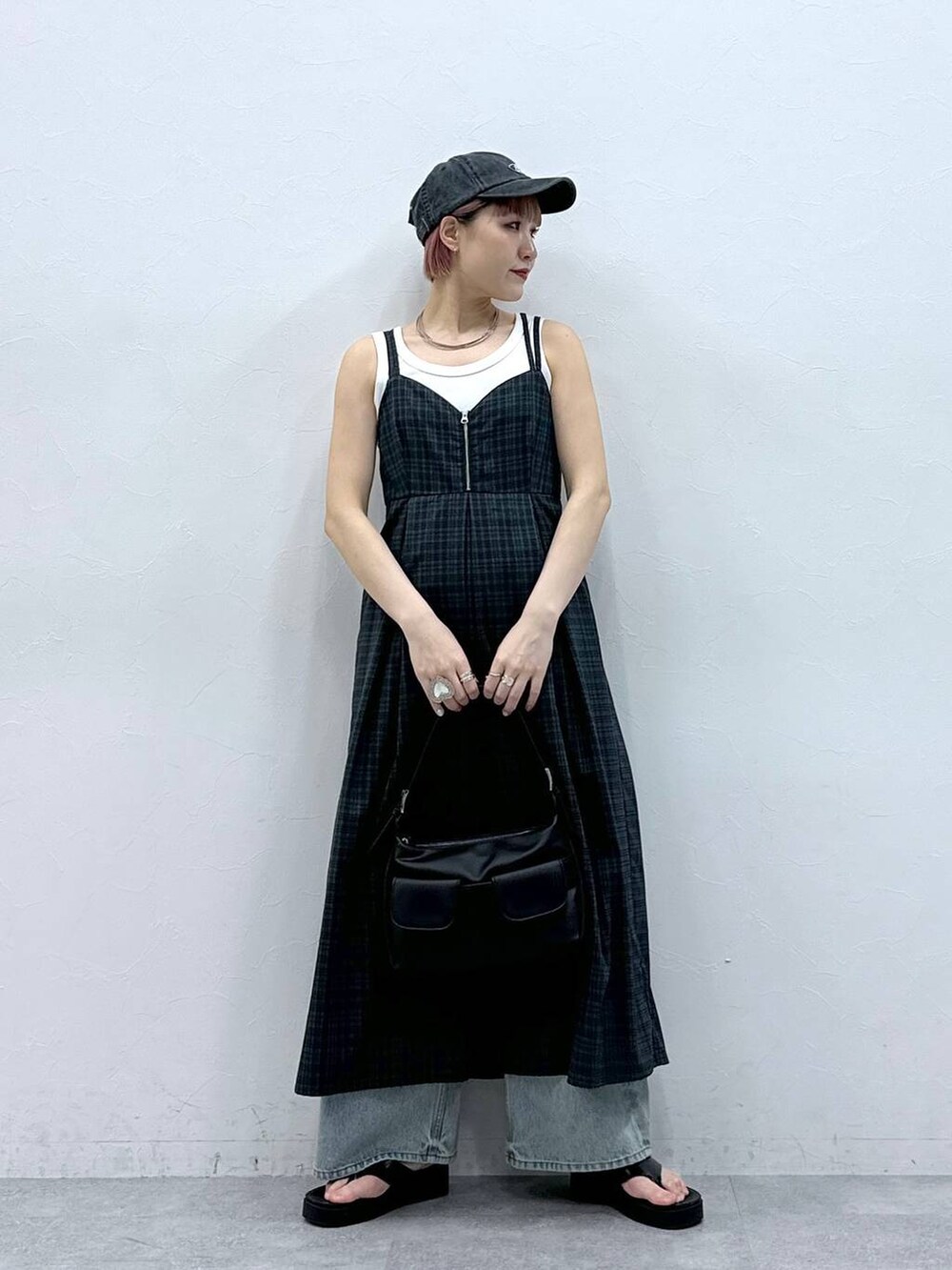 ブルー系のデニムパンツ、グレー系のワンピース、ホワイト系のタンクトップを着用したレディースの春コーディネートの2枚目の写真