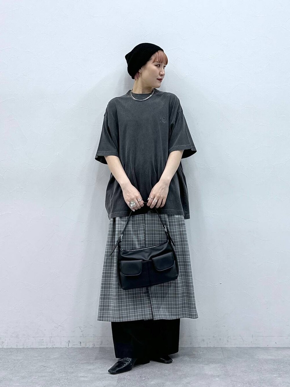 ブラック系のスラックス、グレー系のワンピース、ブラック系のTシャツ/カットソーを着用したレディースの春コーディネートの3枚目の写真