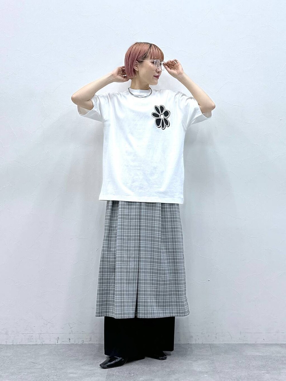 グレー系のワンピース、ホワイト系のTシャツ/カットソー、ブラック系のスラックスを着用したレディースの春コーディネートの4枚目の写真