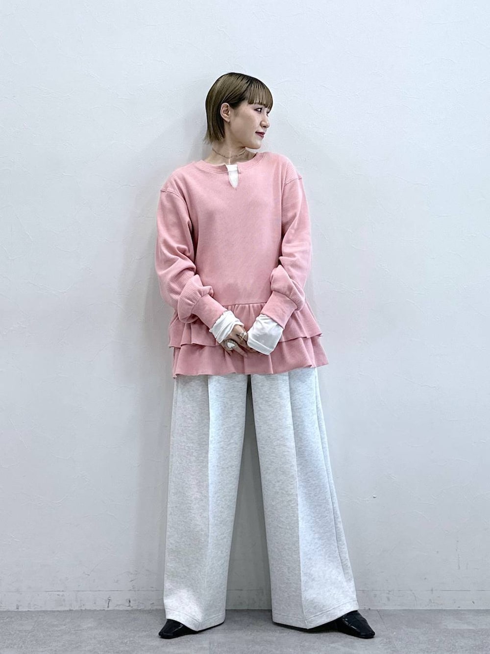 ホワイト系のスウェットパンツ、ピンク系のスウェット、ホワイト系のTシャツ/カットソーを着用したレディースの冬コーディネートの2枚目の写真