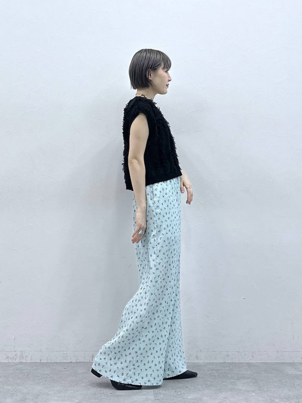 ブルー系のスラックス、ブラック系のベストを着用したレディースの春コーディネートの5枚目の写真