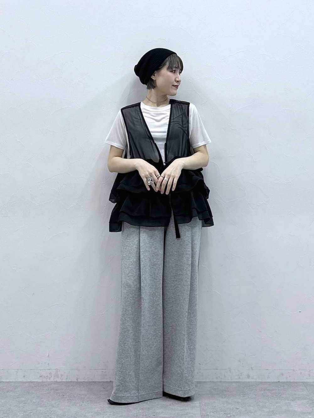 グレー系のスウェットパンツ、ホワイト系のTシャツ/カットソー、ブラック系のベストを着用したレディースの春コーディネートの5枚目の写真