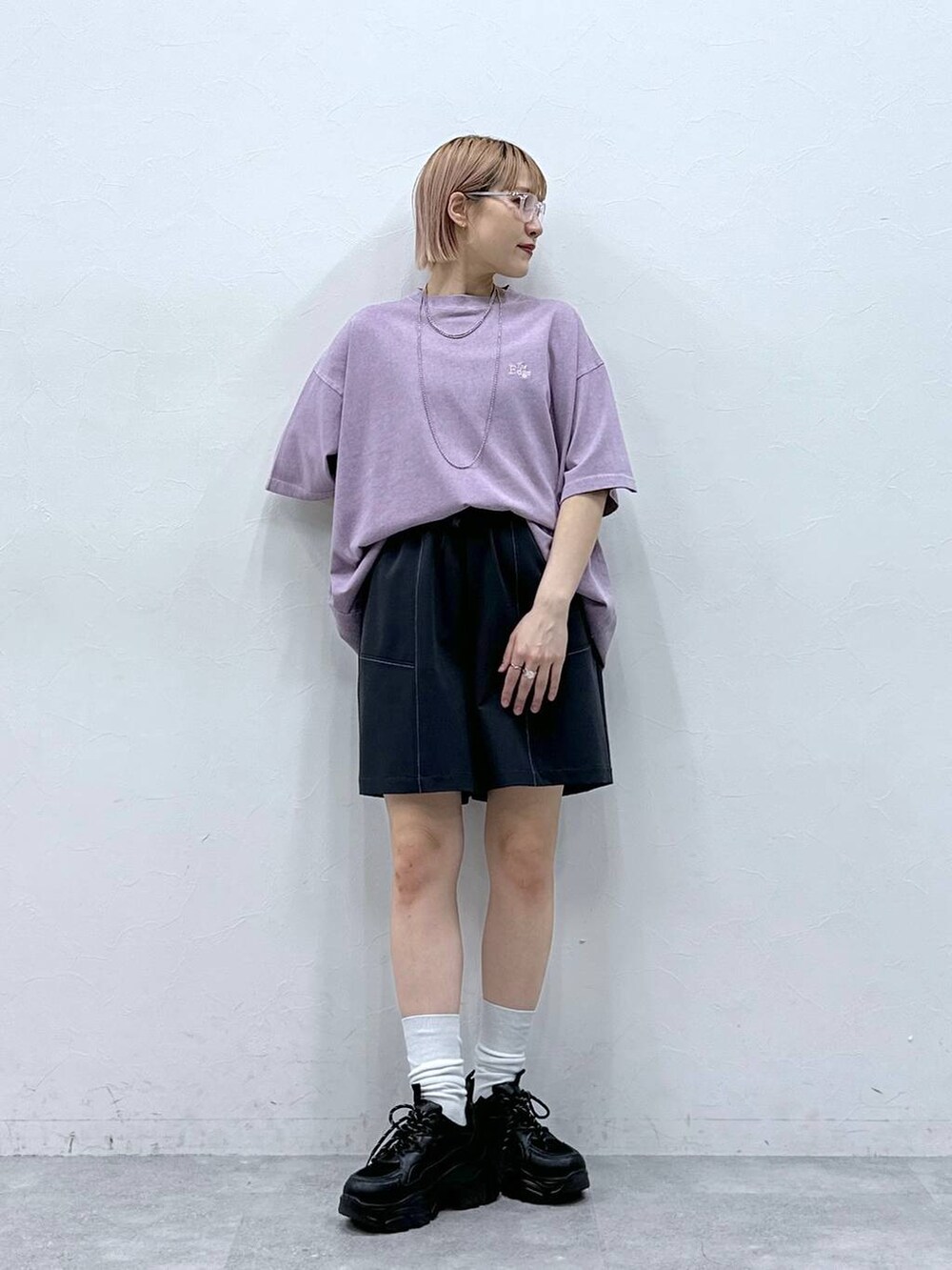 ブラック系のスニーカー、ブルー系のスラックス、ピンク系のTシャツ/カットソーを着用したレディースの春コーディネートの2枚目の写真